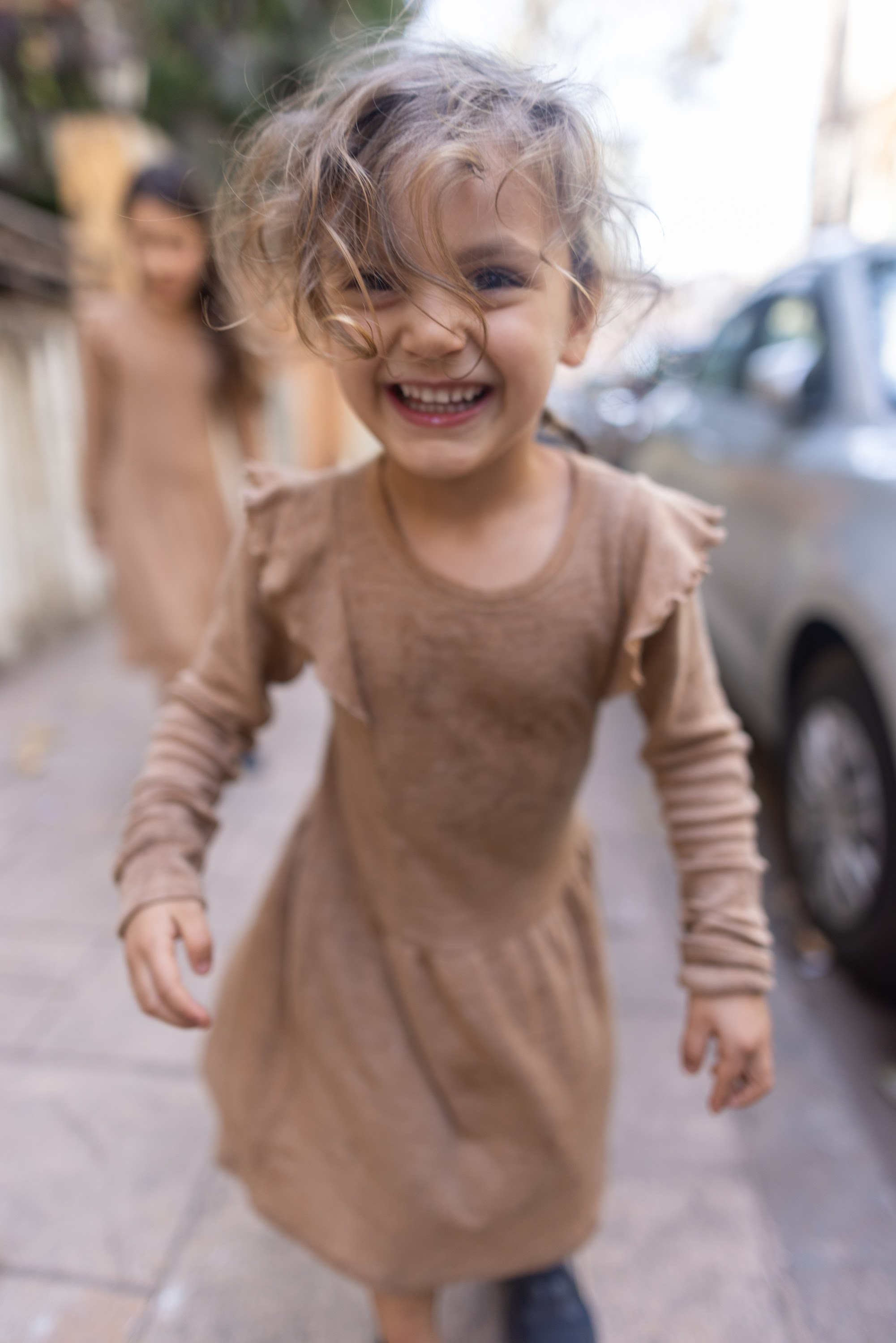Joyful Girl Running on City Sidewalk