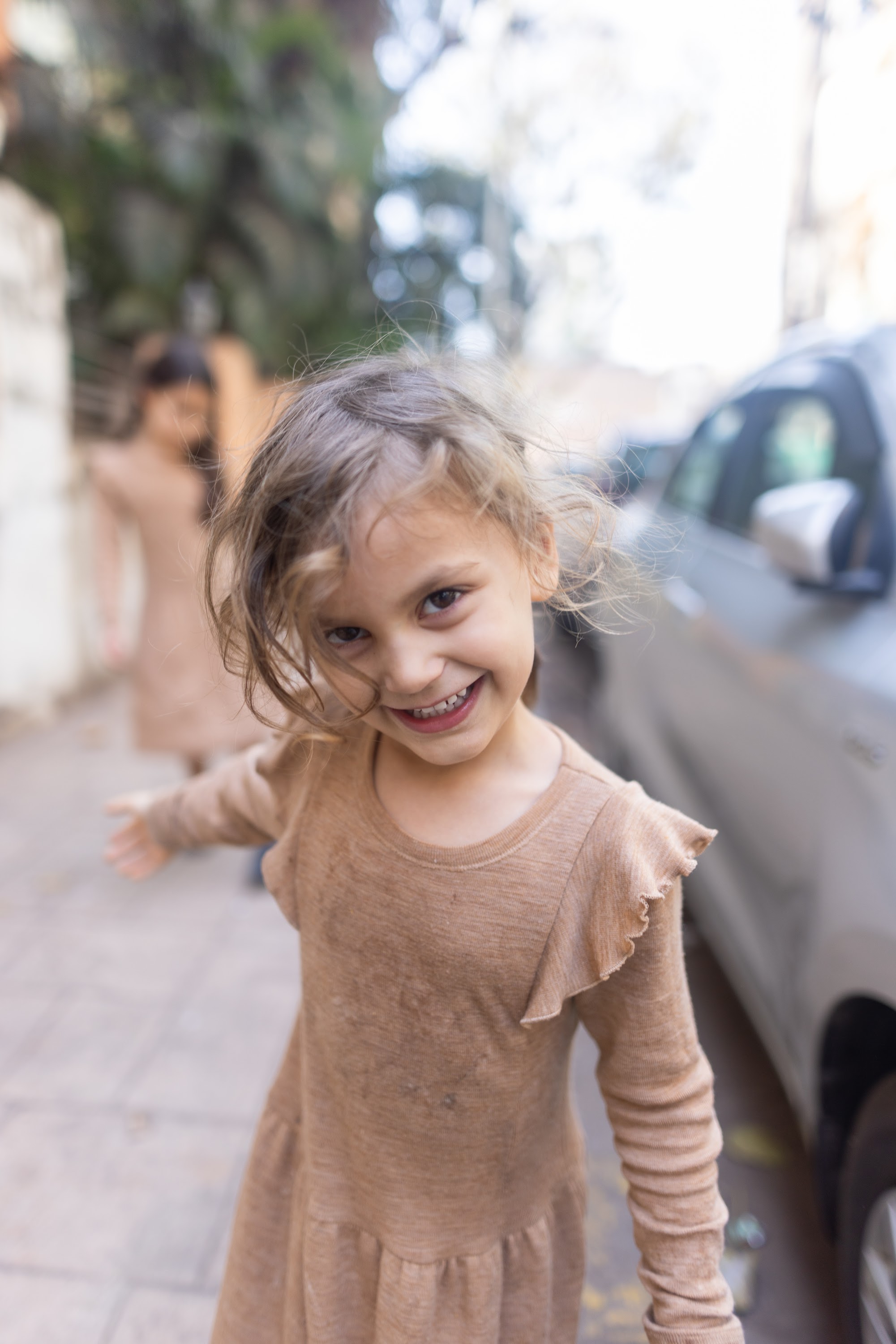 Smiling Girl on Sidewalk with Blurred Background