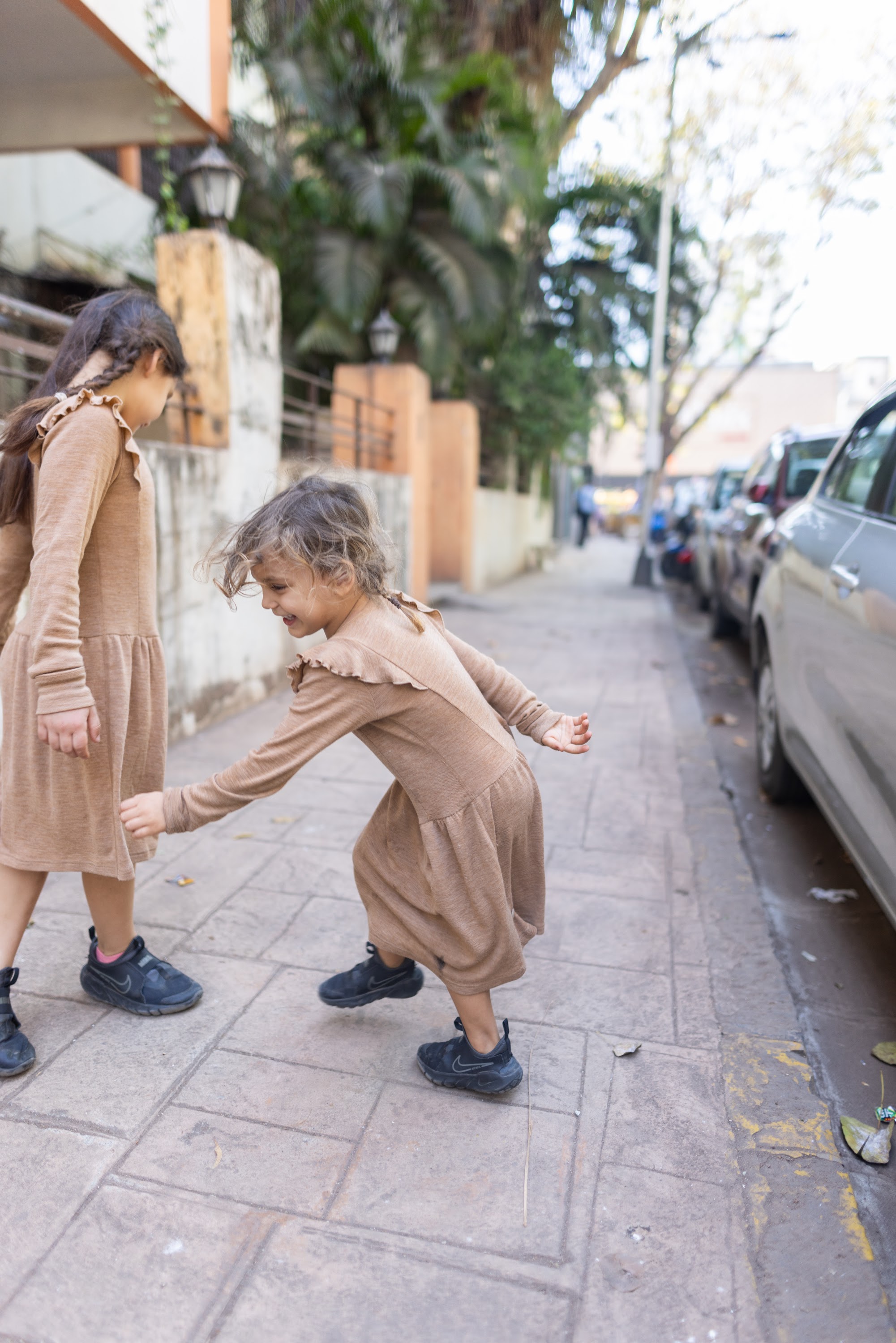 Two Girls Playing on a Sidewalk