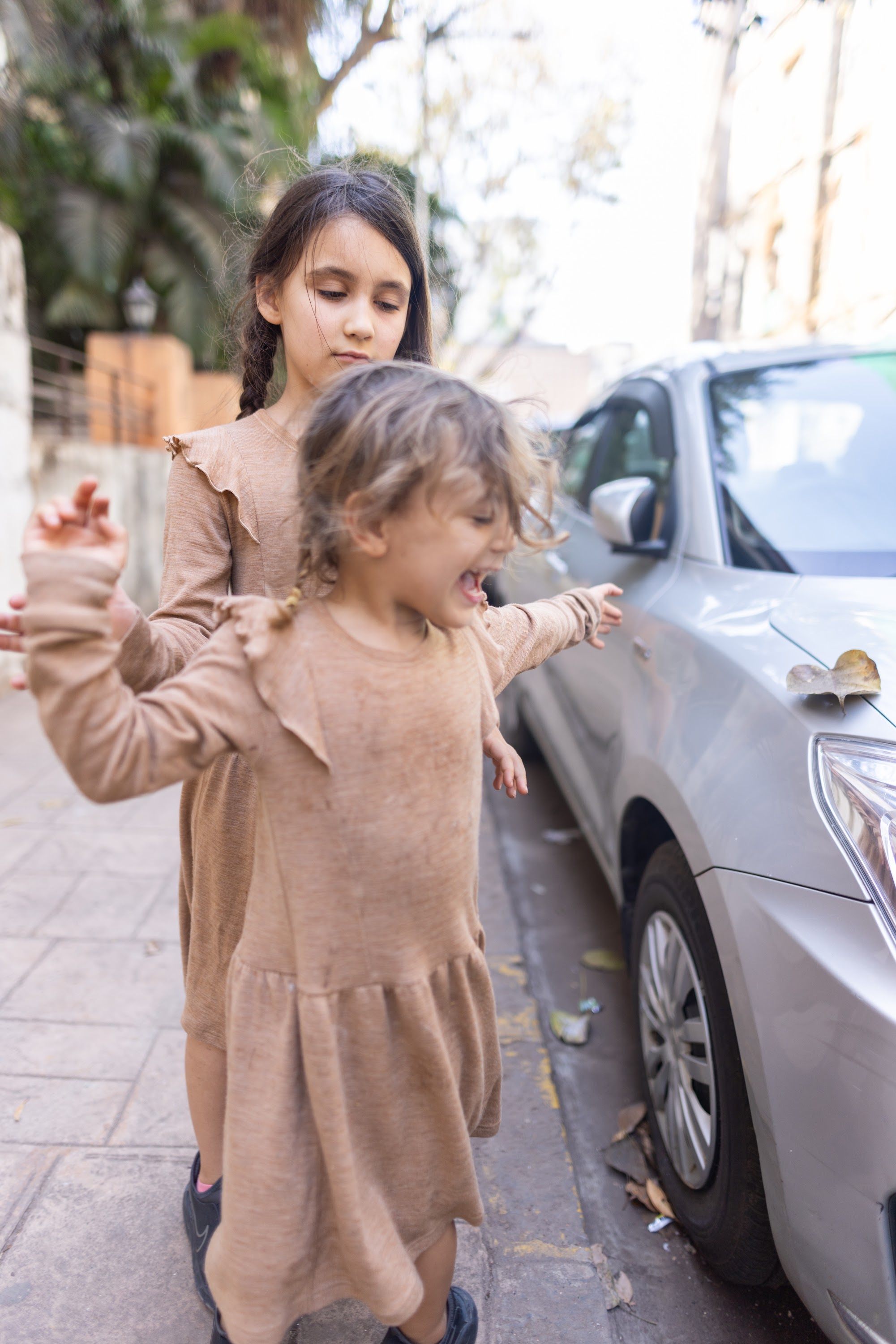 Two Girls Playing on a City Sidewalk