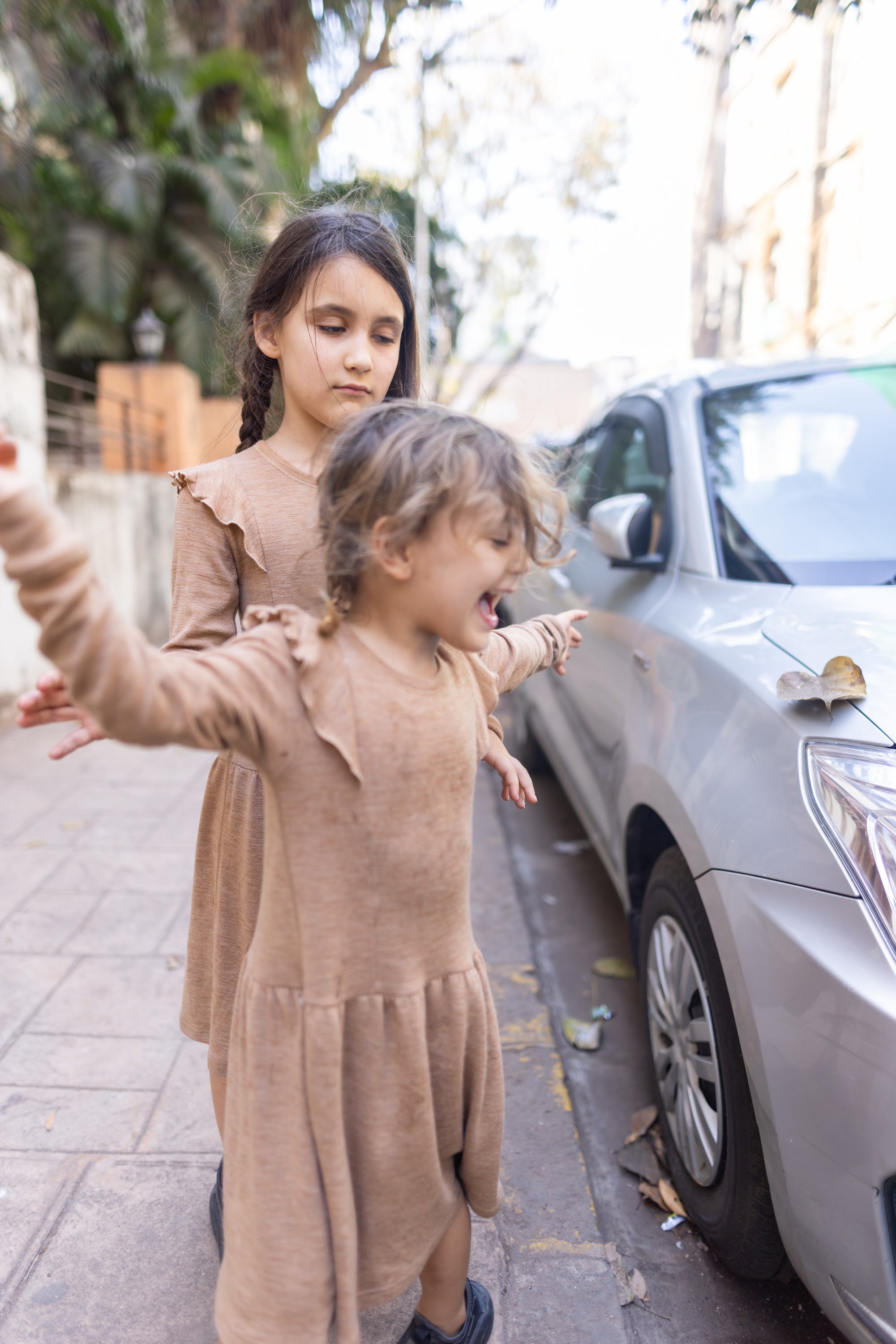 Two Girls Playing on a Sidewalk