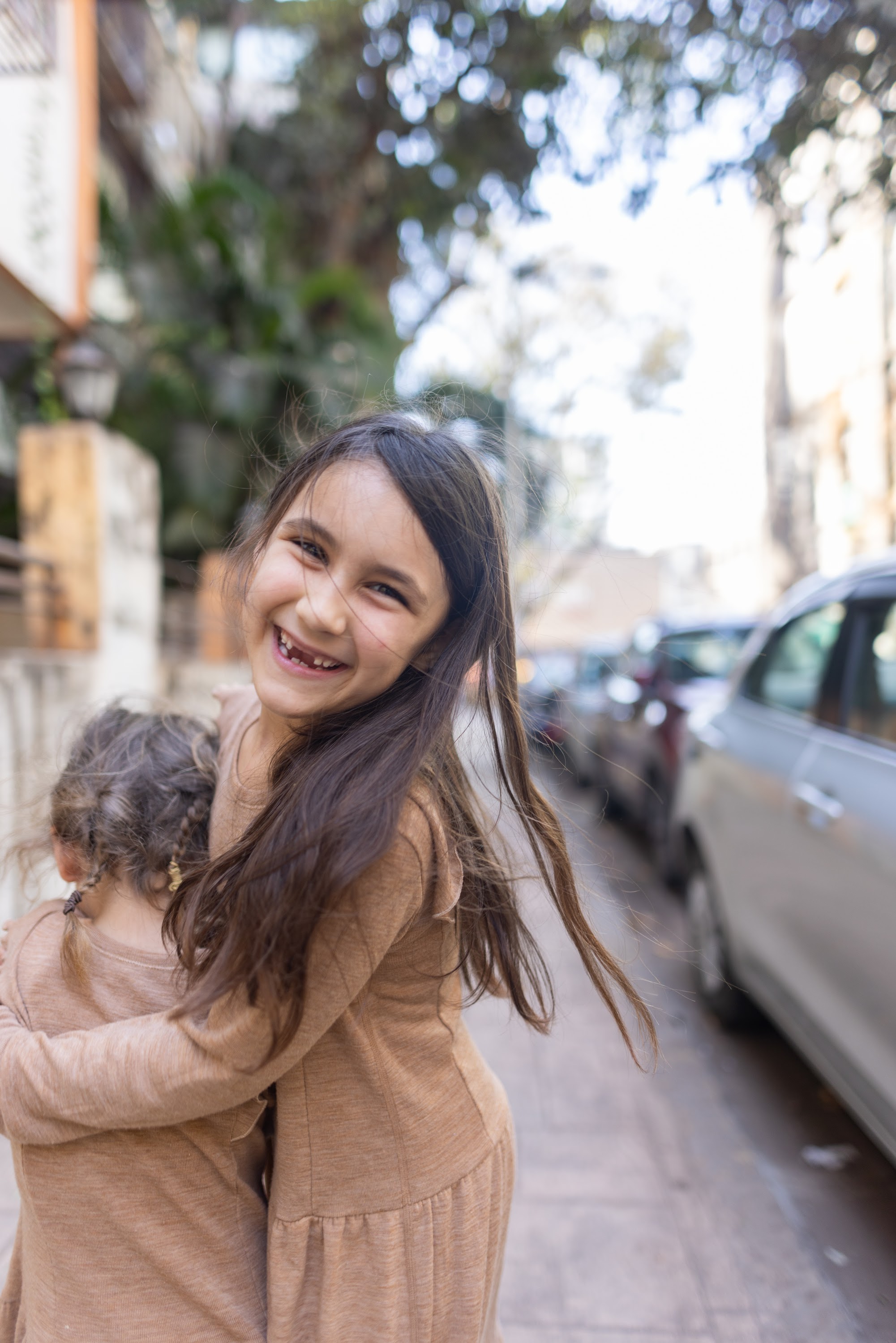 Two Girls Hugging on a Street