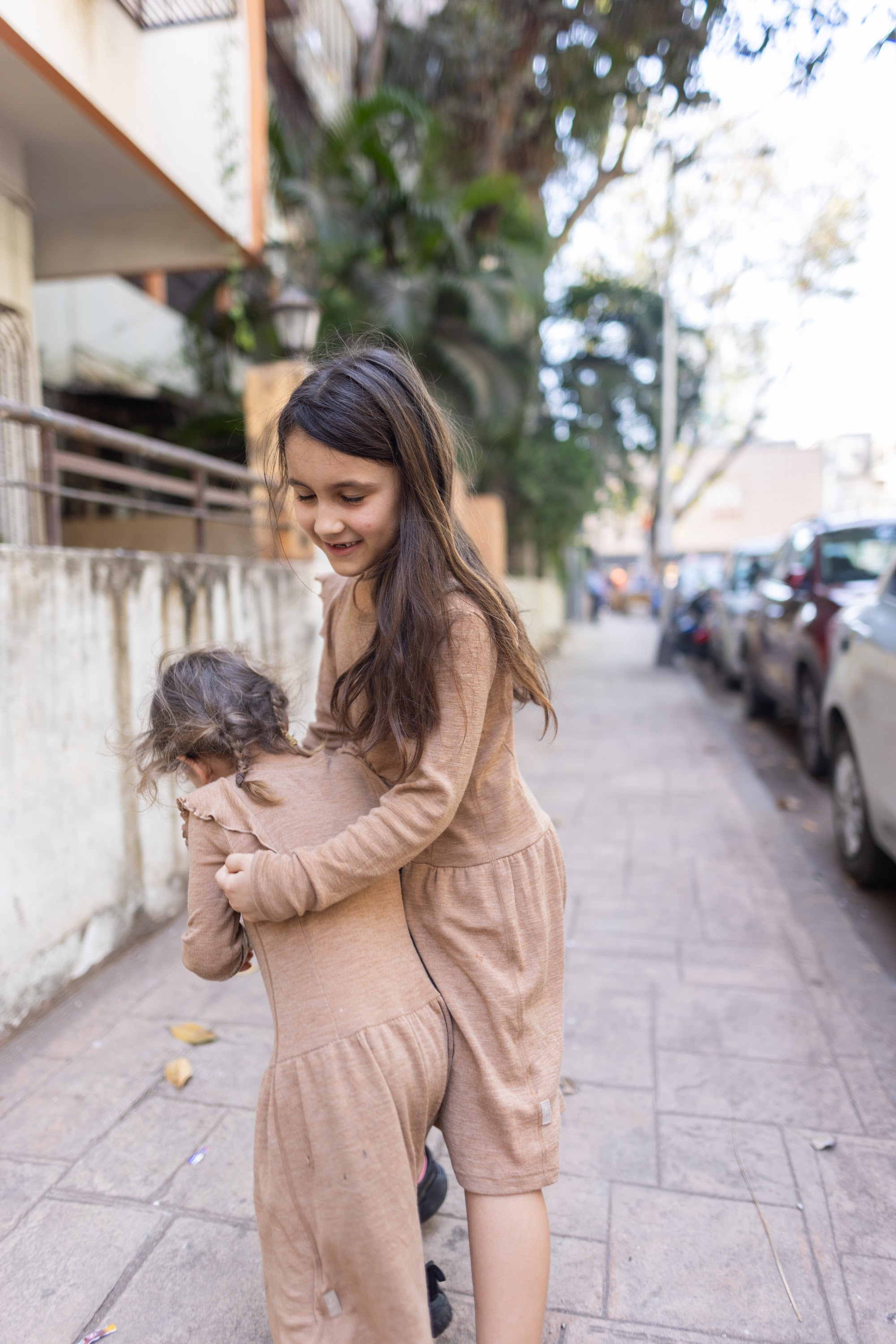 Two Girls Playing on a City Sidewalk