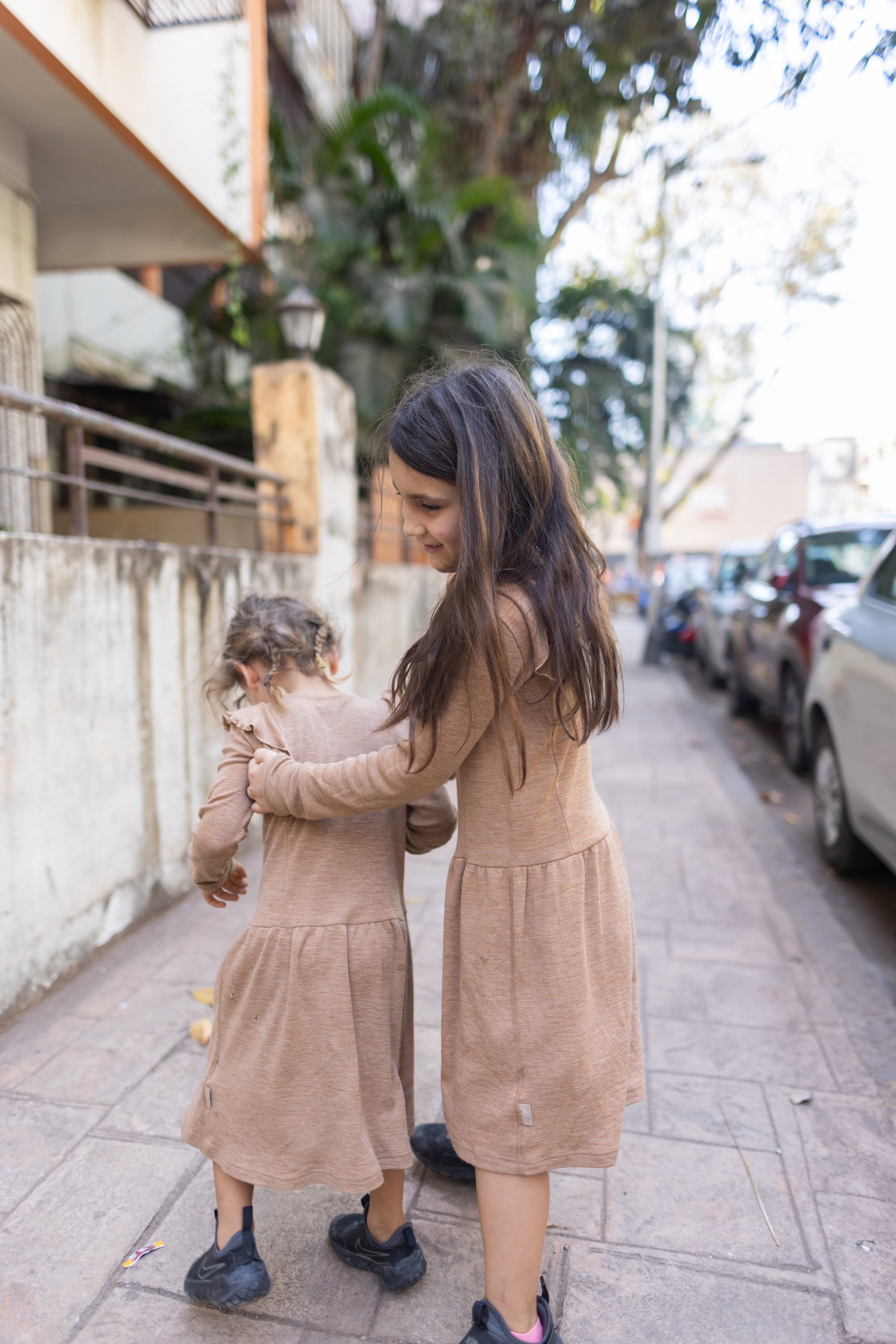Two Girls Walking on a City Sidewalk