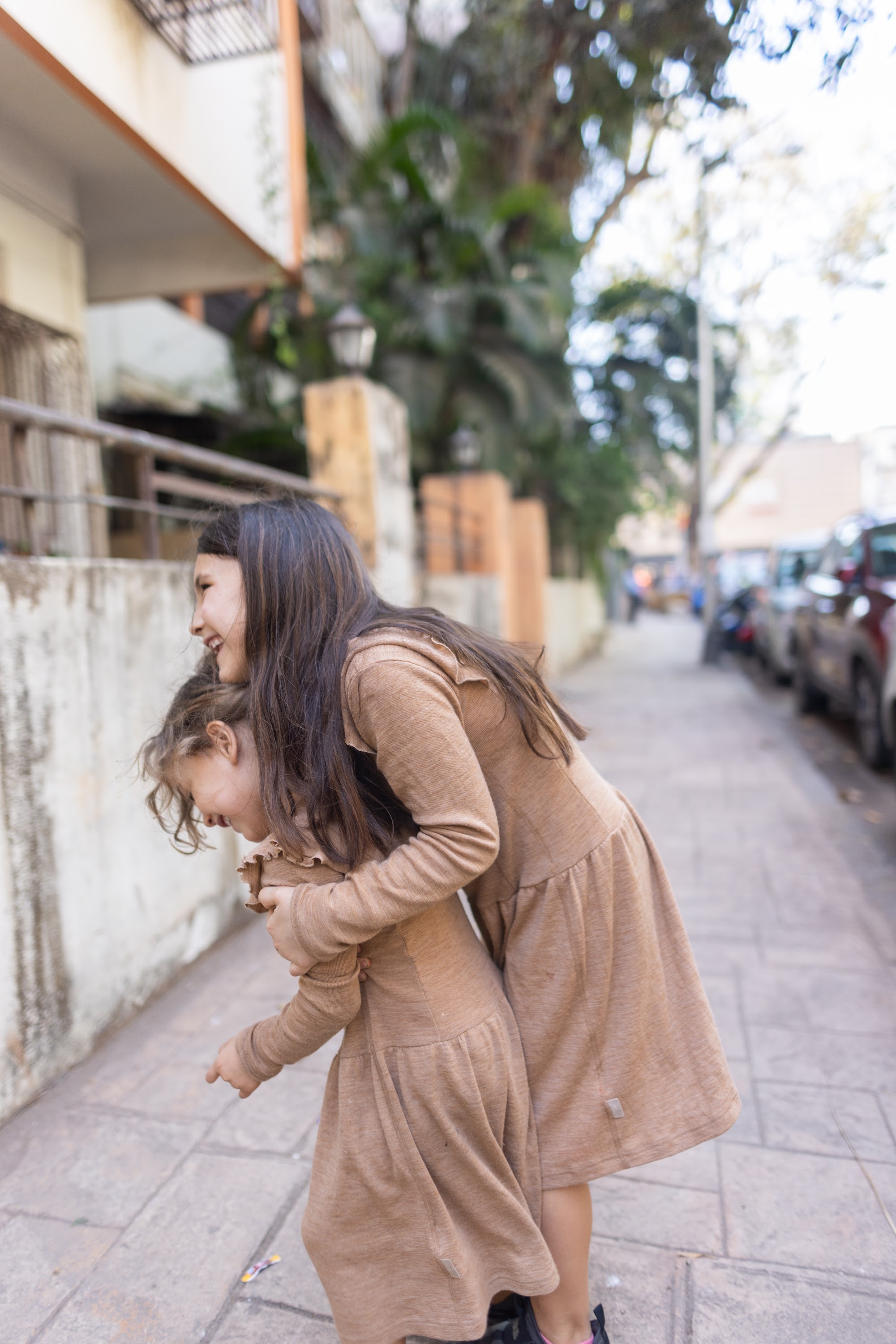 Two Girls Playing on a City Sidewalk