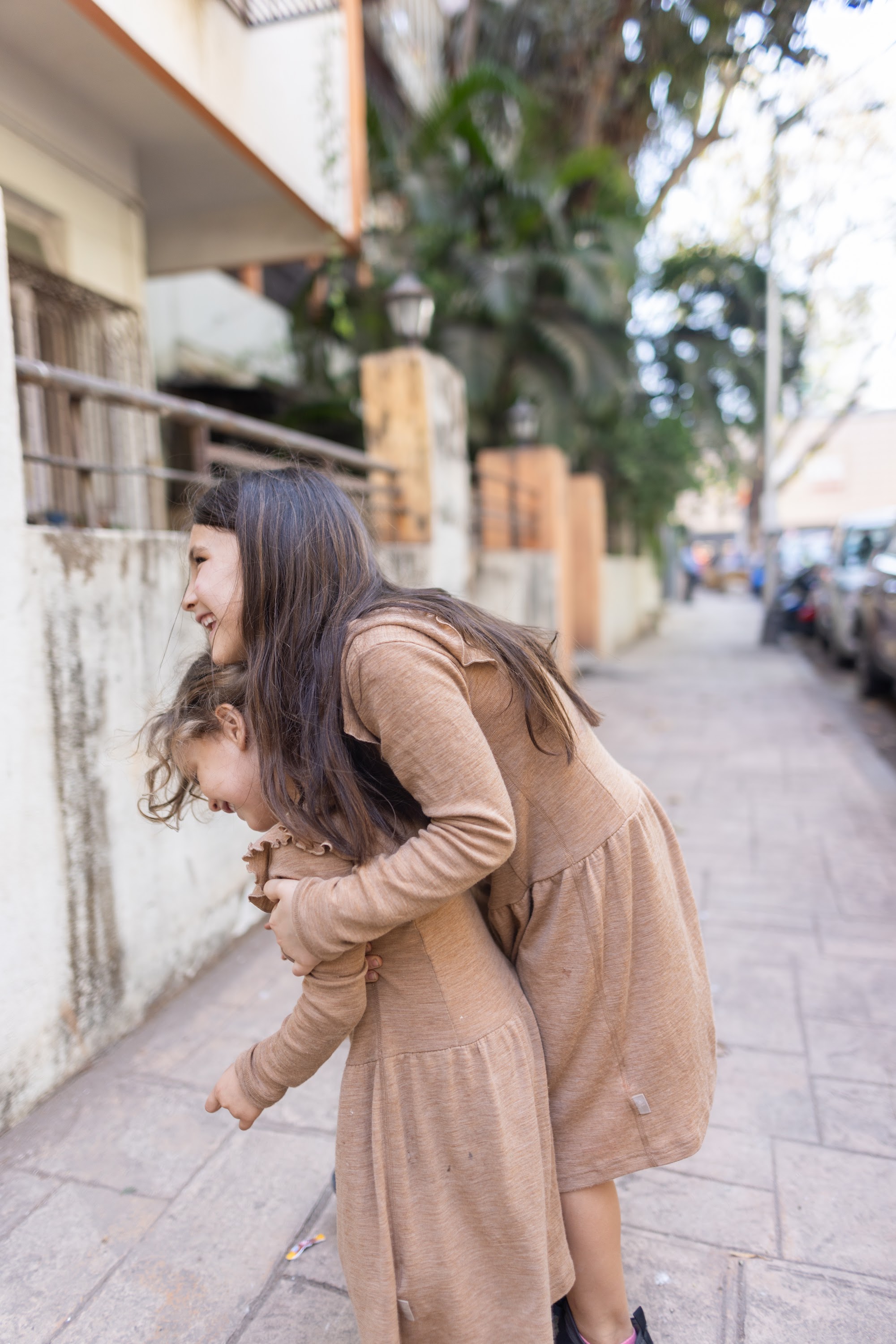 Mother and Daughter Sharing a Joyful Moment on a Sidewalk