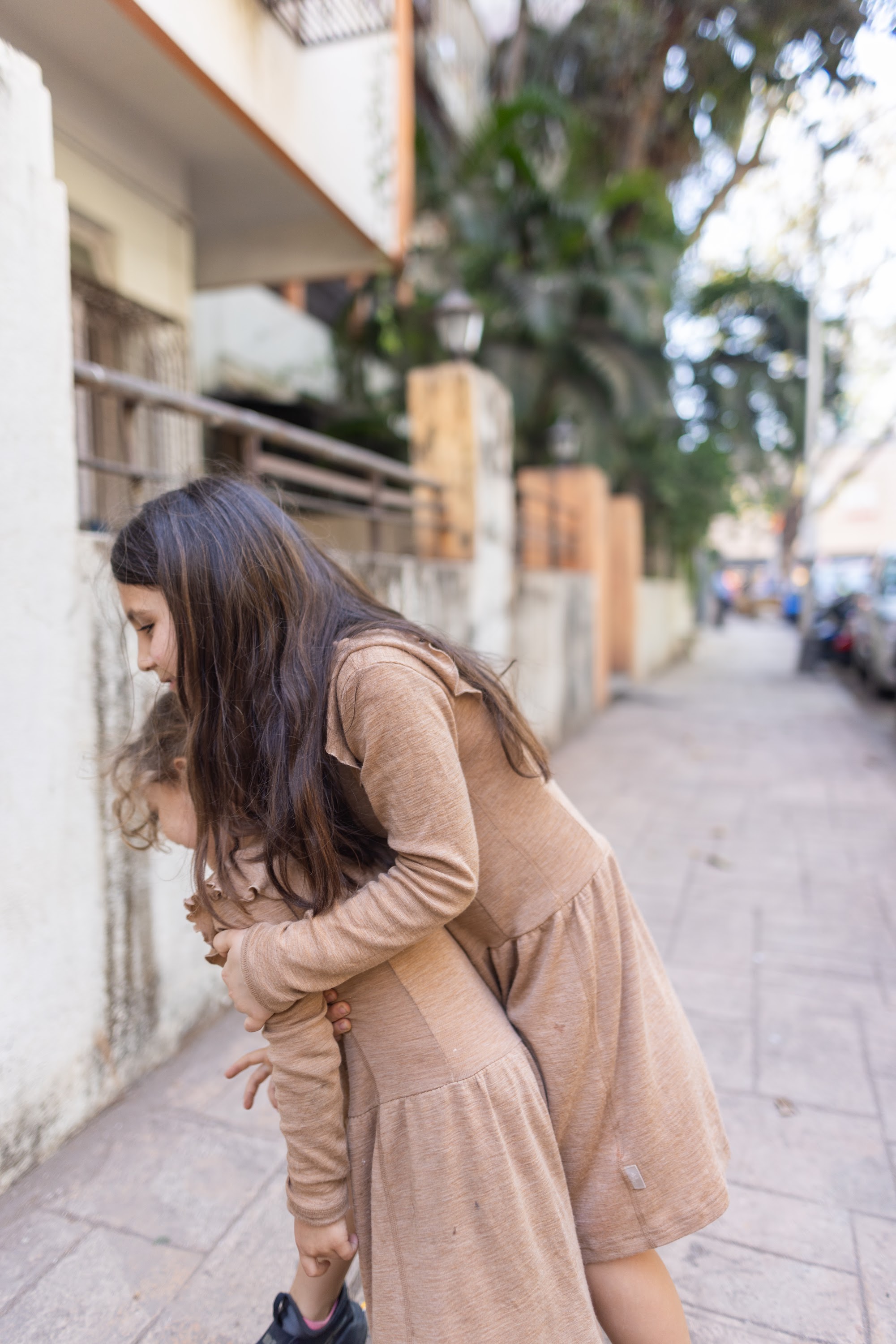 Sibling Embrace on a City Sidewalk