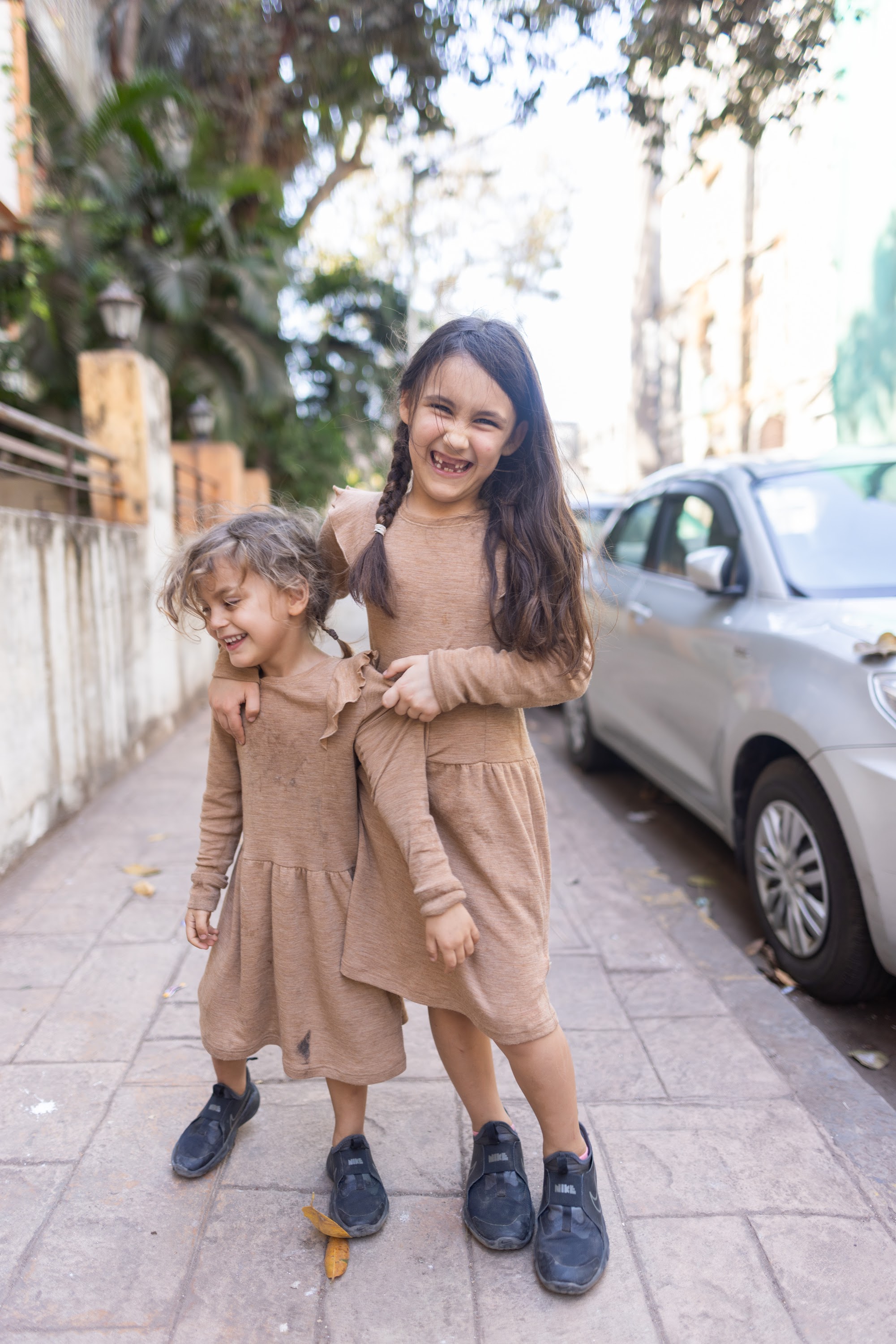 Two Girls Laughing on a Sidewalk