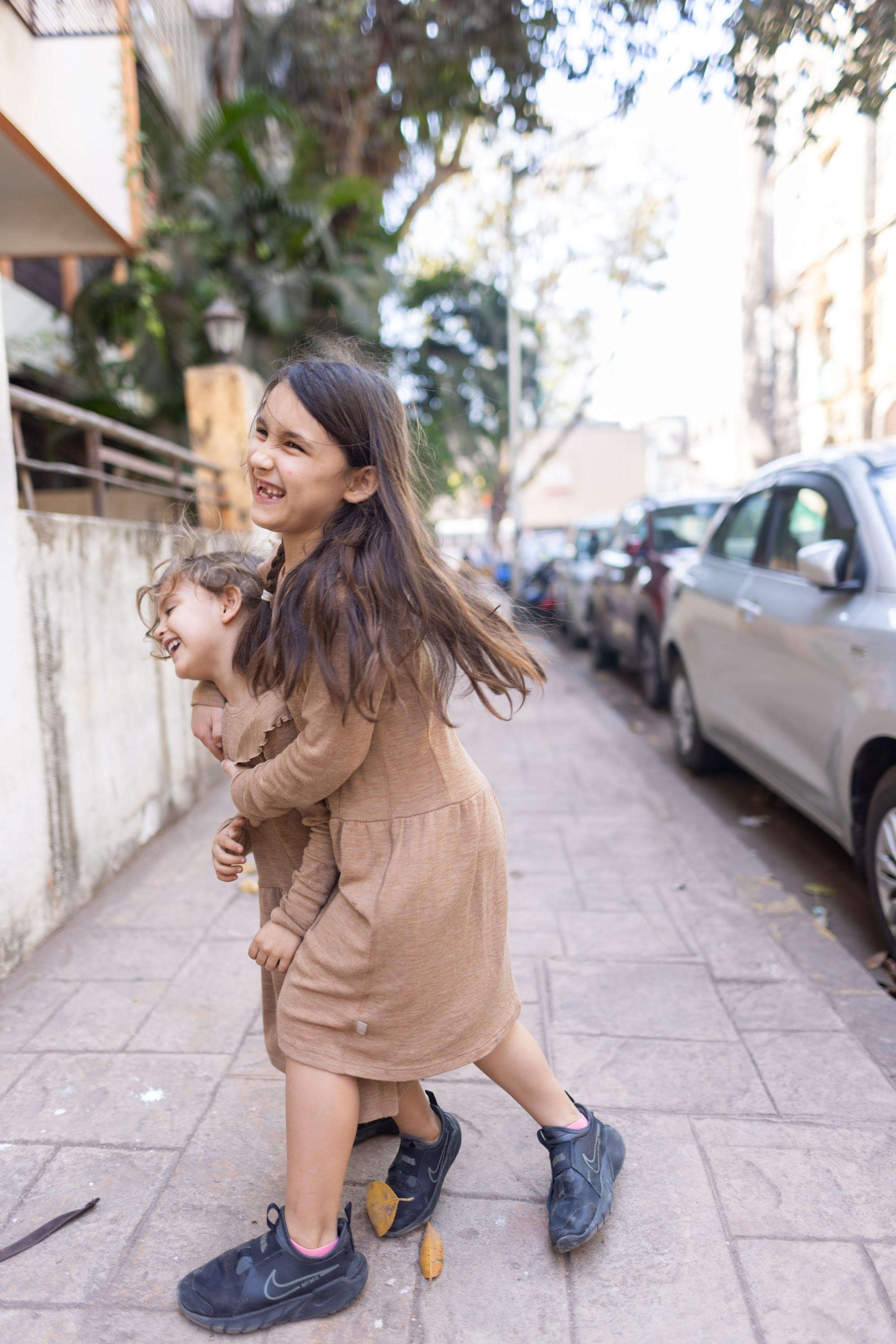 Two Girls Playing on a City Sidewalk