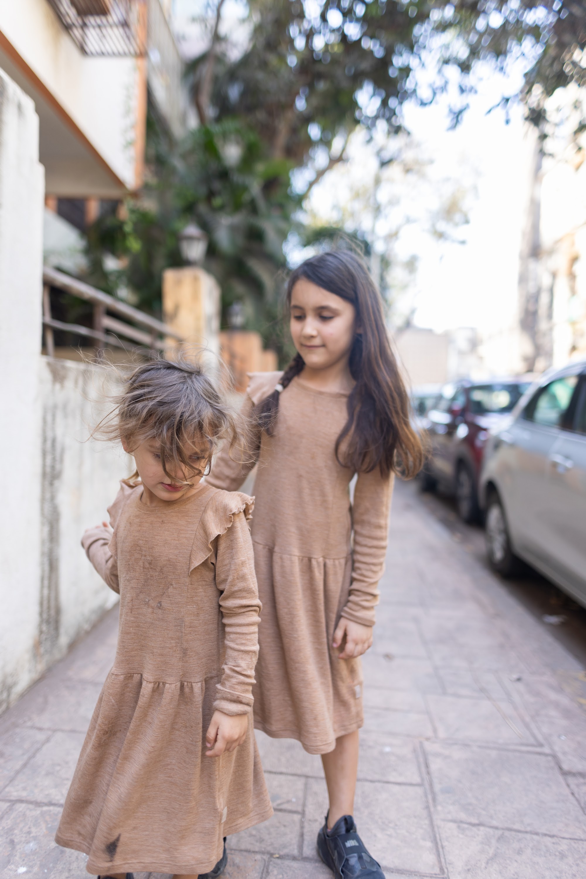 Two Girls Walking on a Sidewalk
