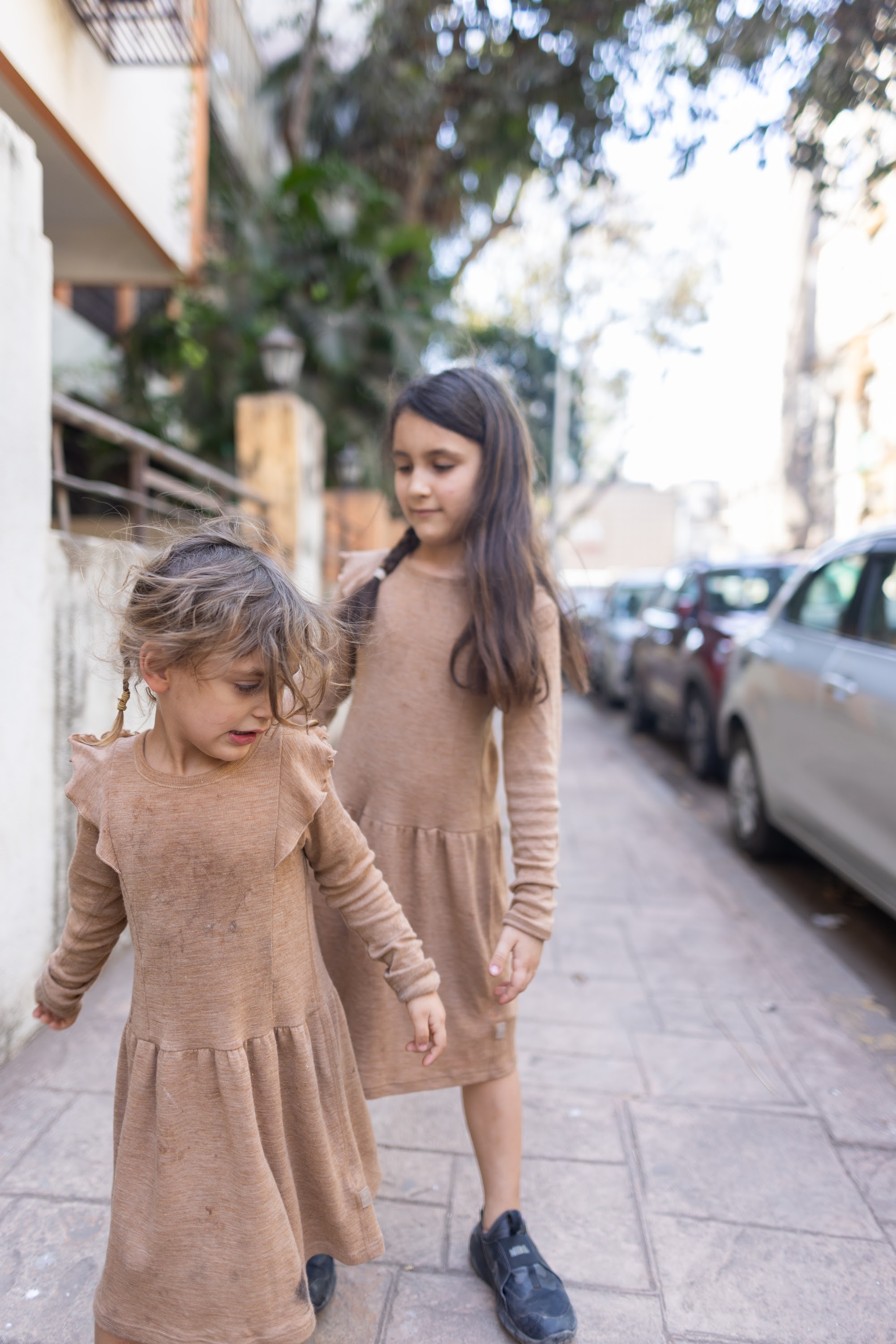 Two Girls Walking on a Sidewalk