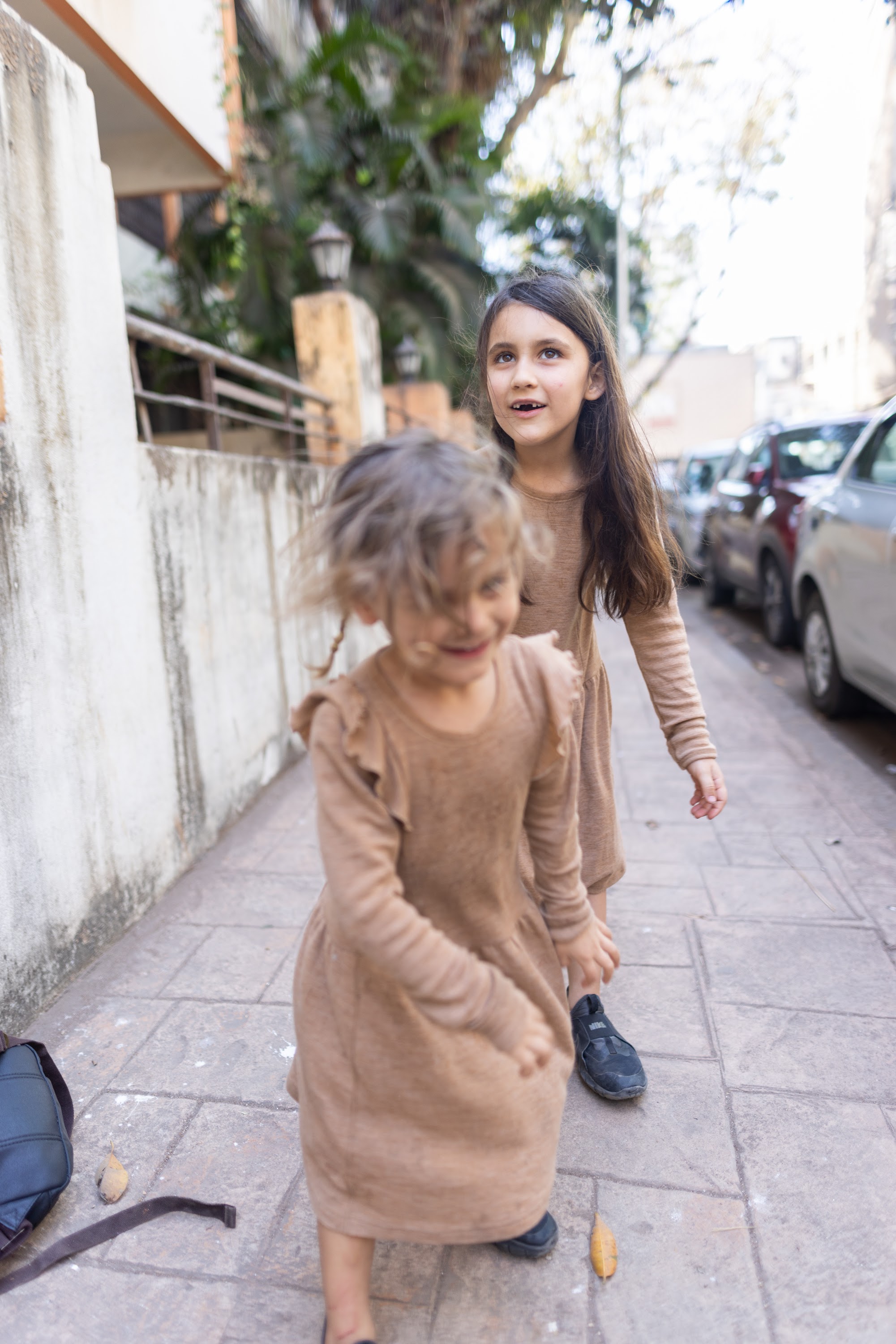 Two Girls Walking on a Sidewalk