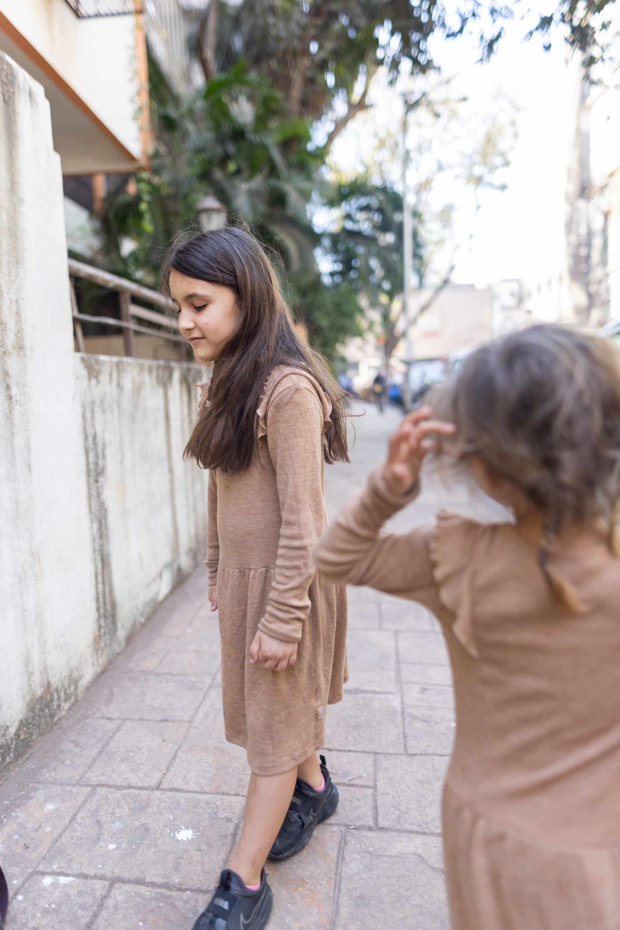 Two Girls Walking on a Sidewalk