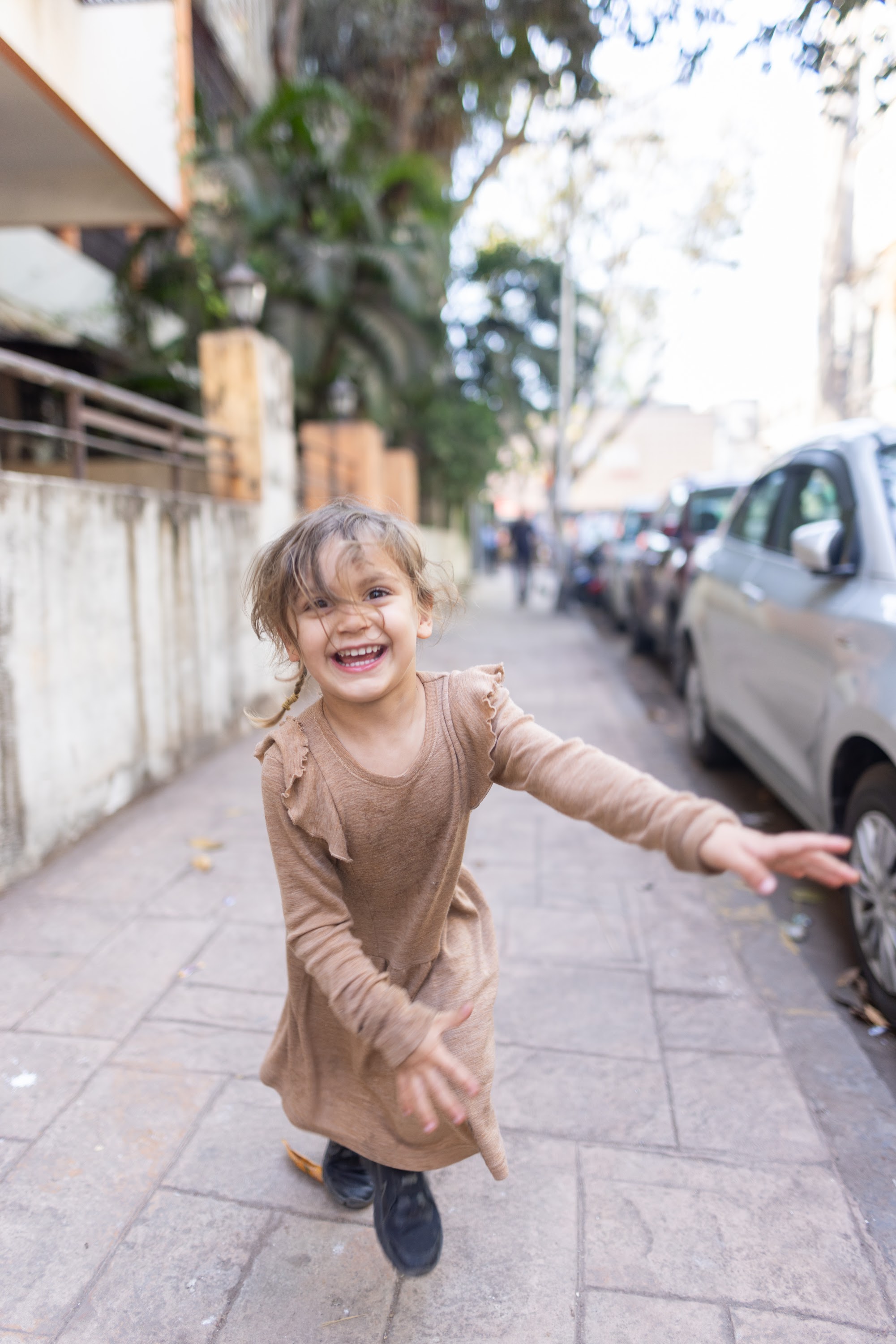 Happy Child Running on Sidewalk