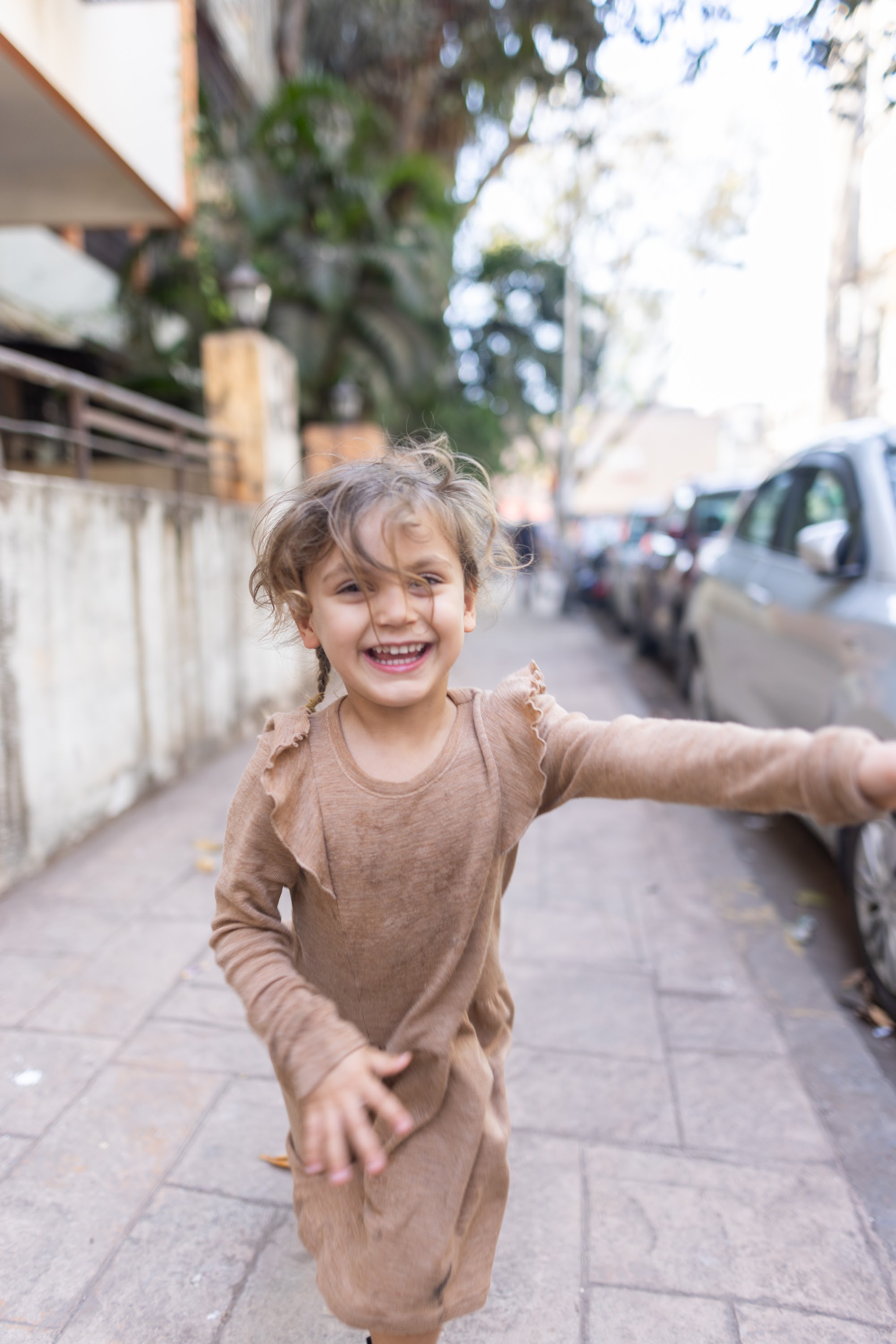 Happy Child Running on Sidewalk