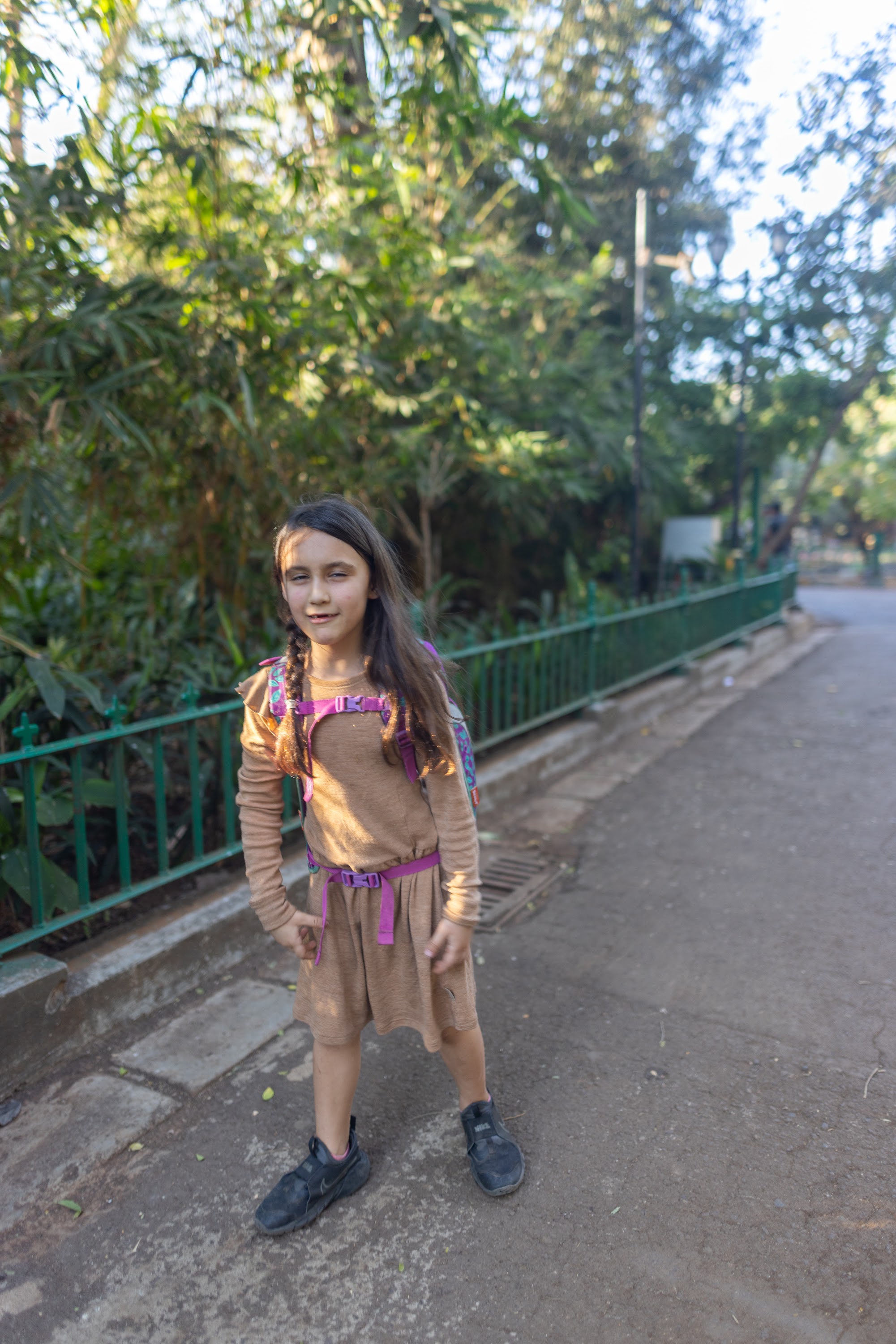 Girl with Backpack Standing on Pathway