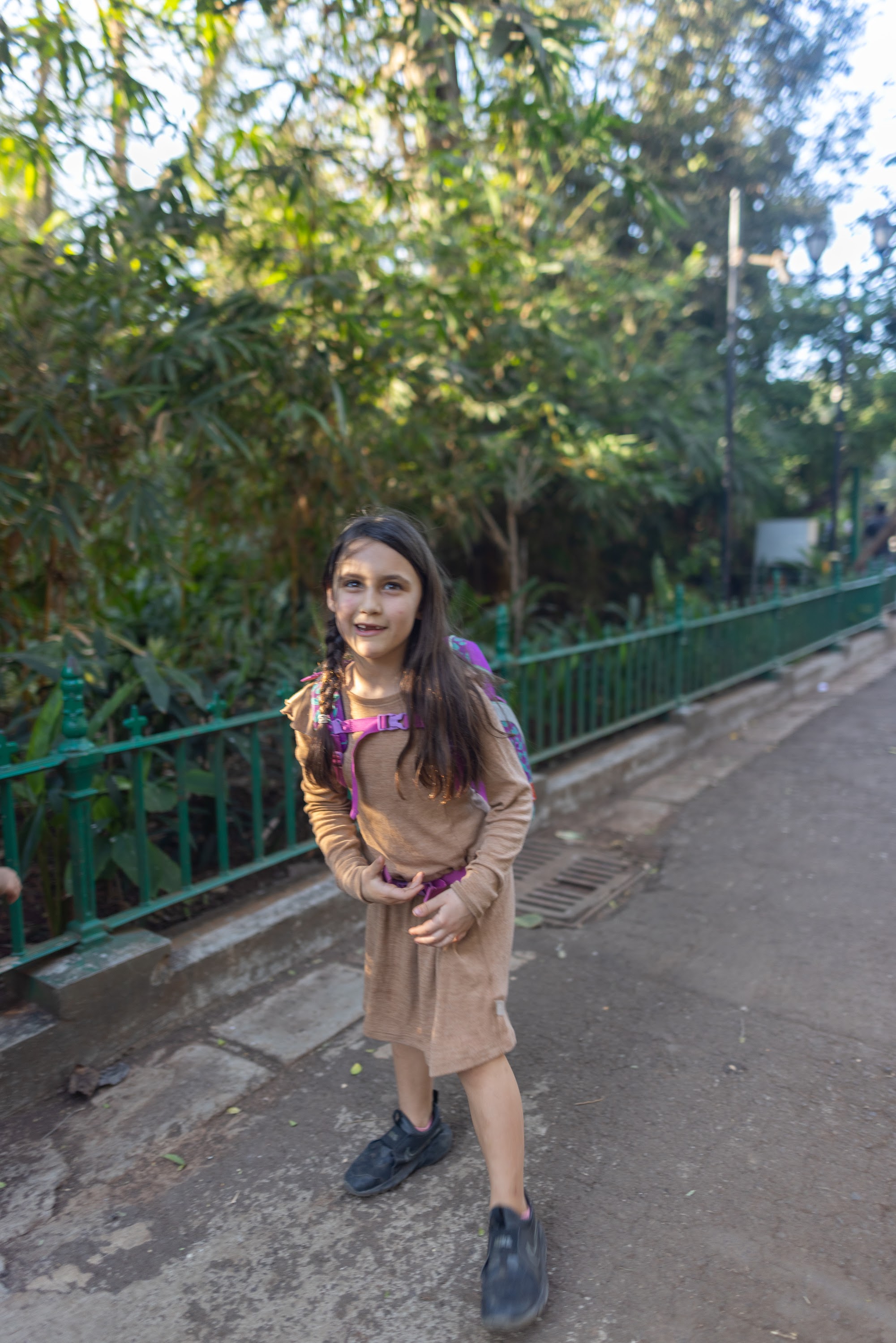 Girl in Backpack Smiling on Pathway