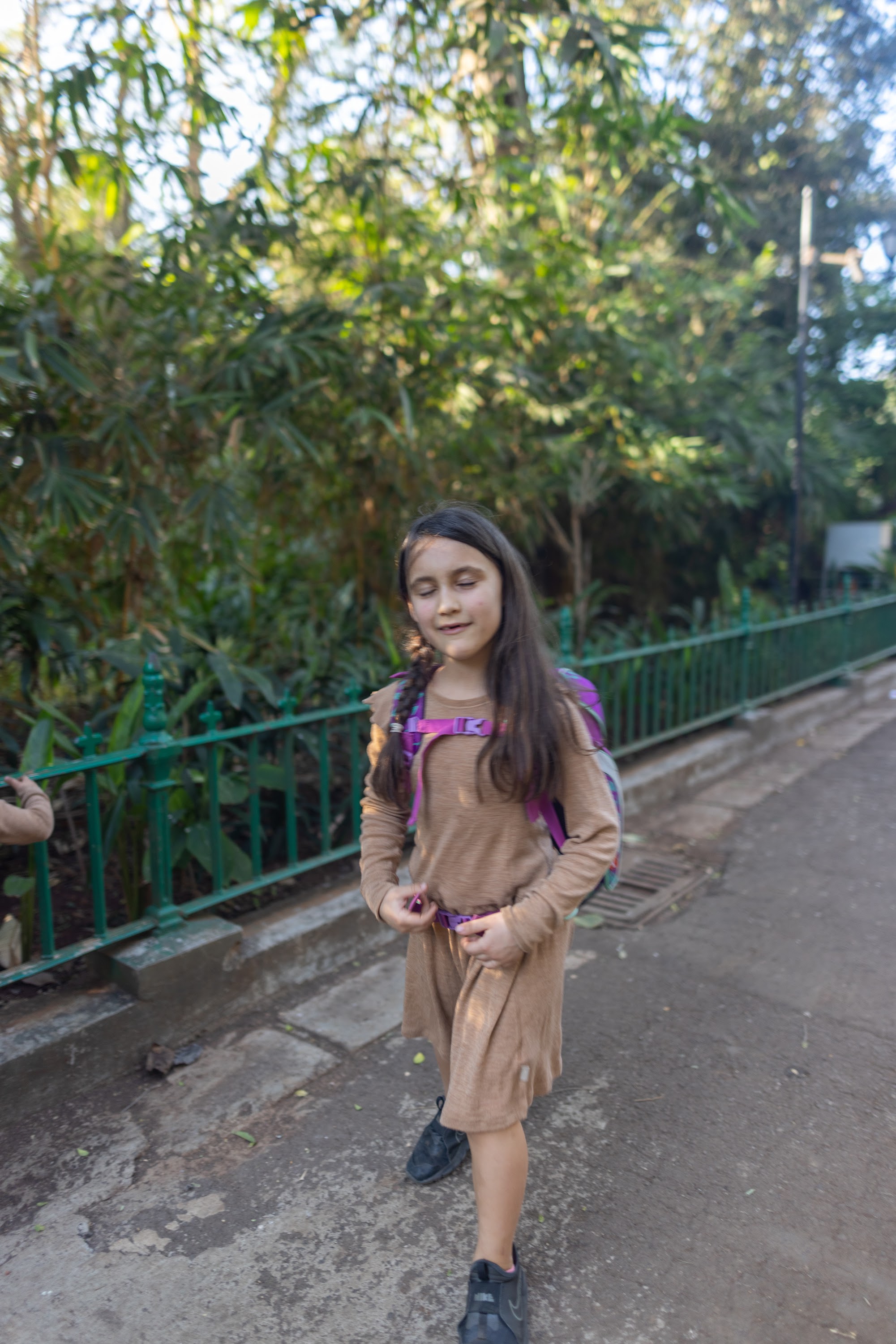 Girl Walking in a Garden Path with Backpack