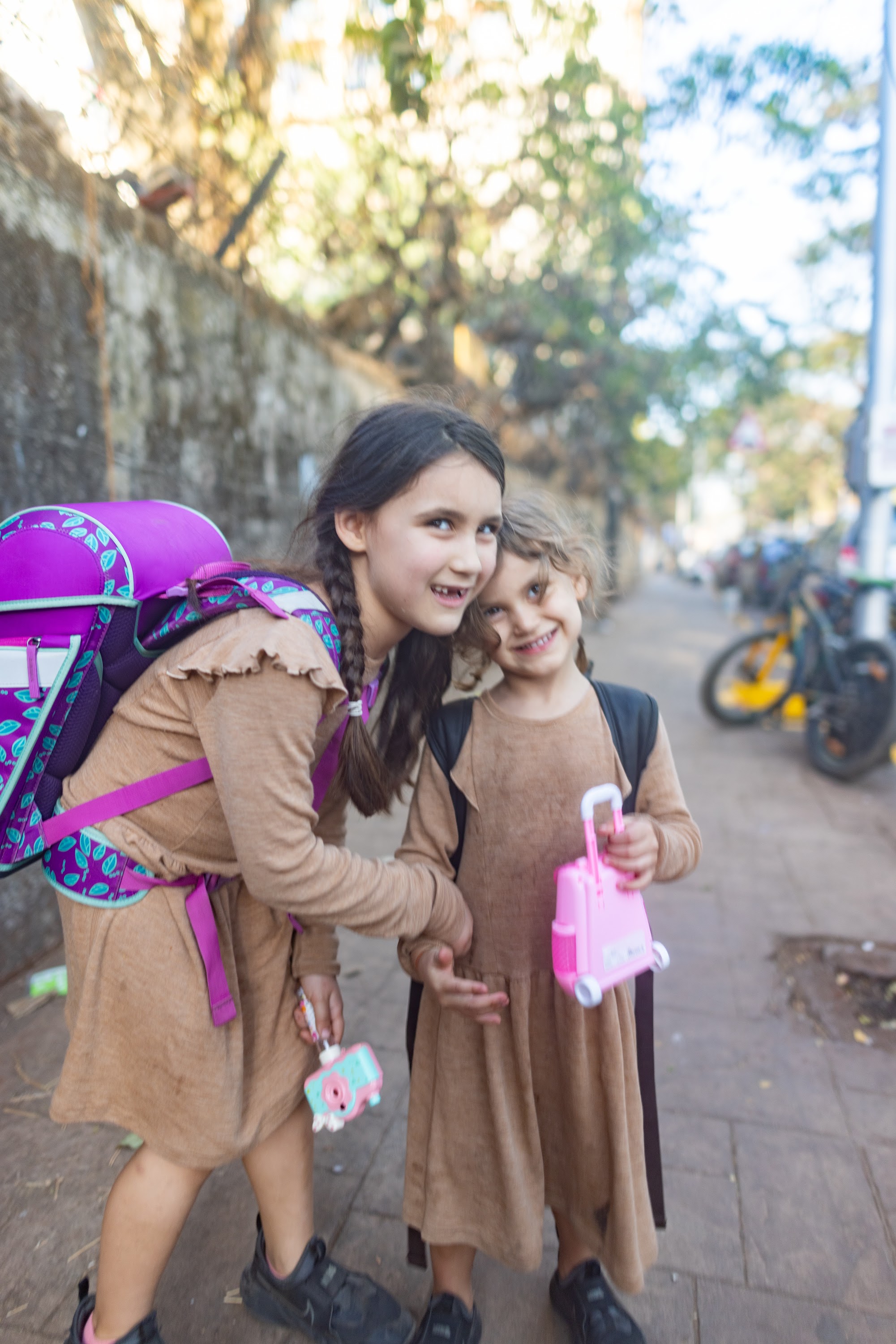 Two Girls in Matching Dresses on a Sunny Street