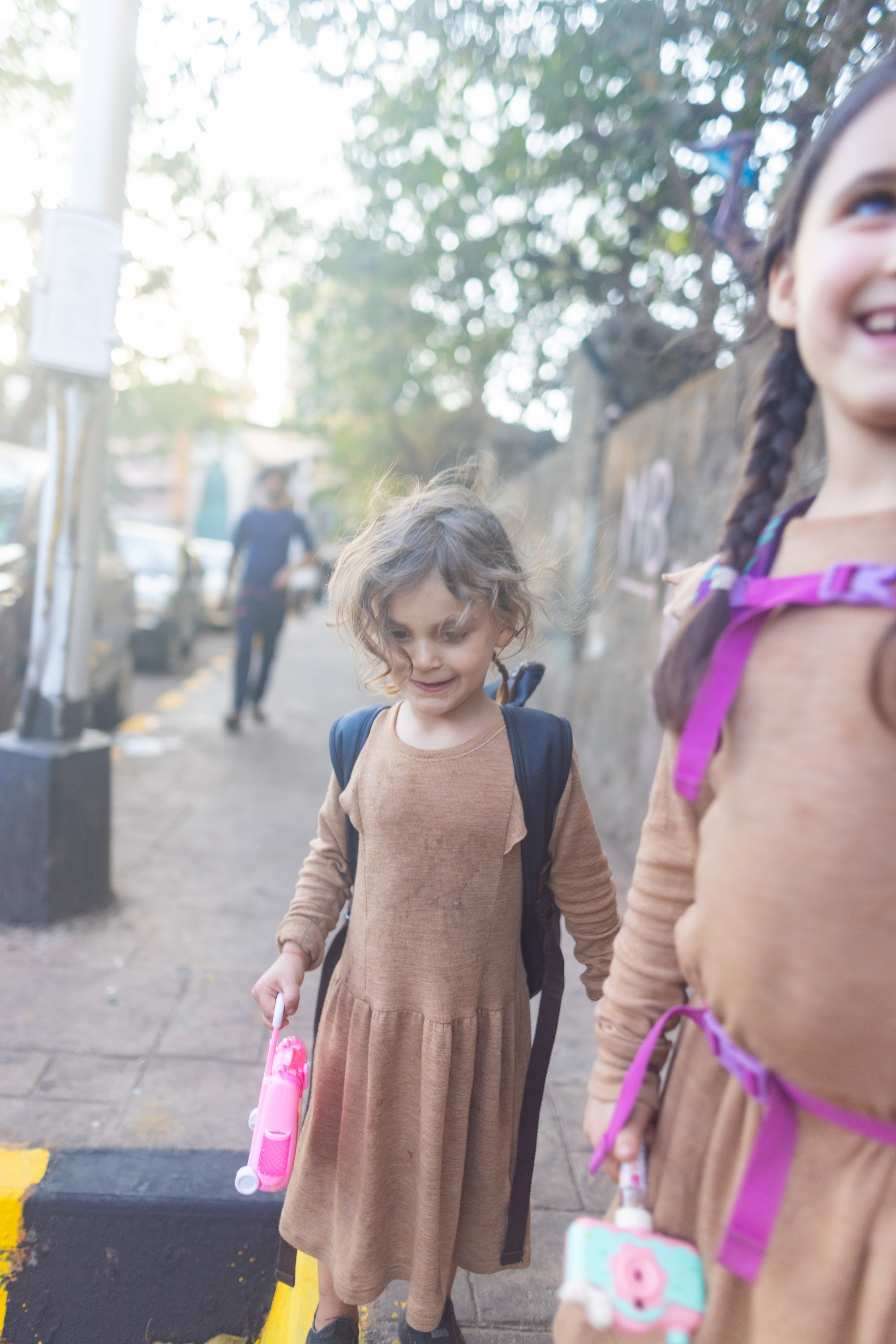 Two Girls Walking on a Sidewalk
