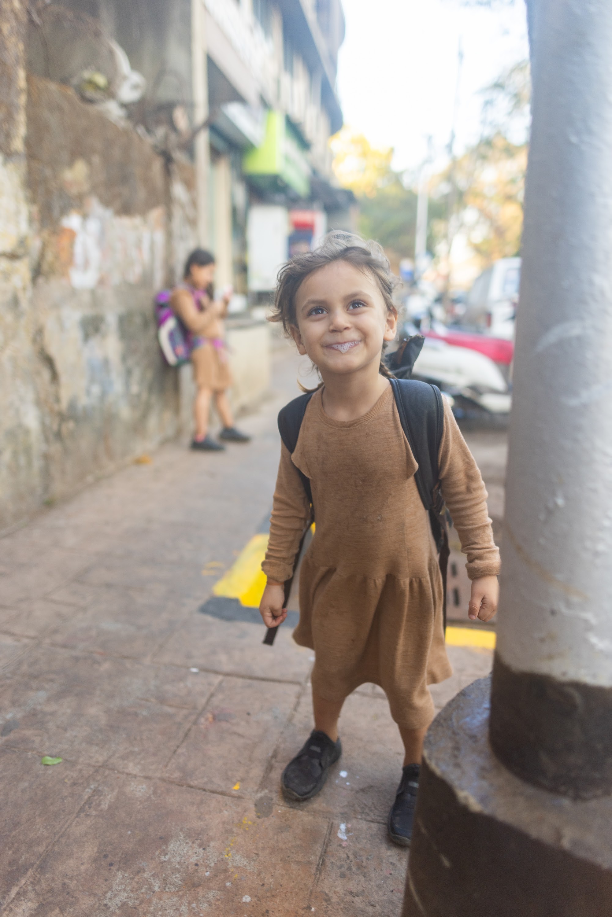 Smiling Child on Urban Sidewalk