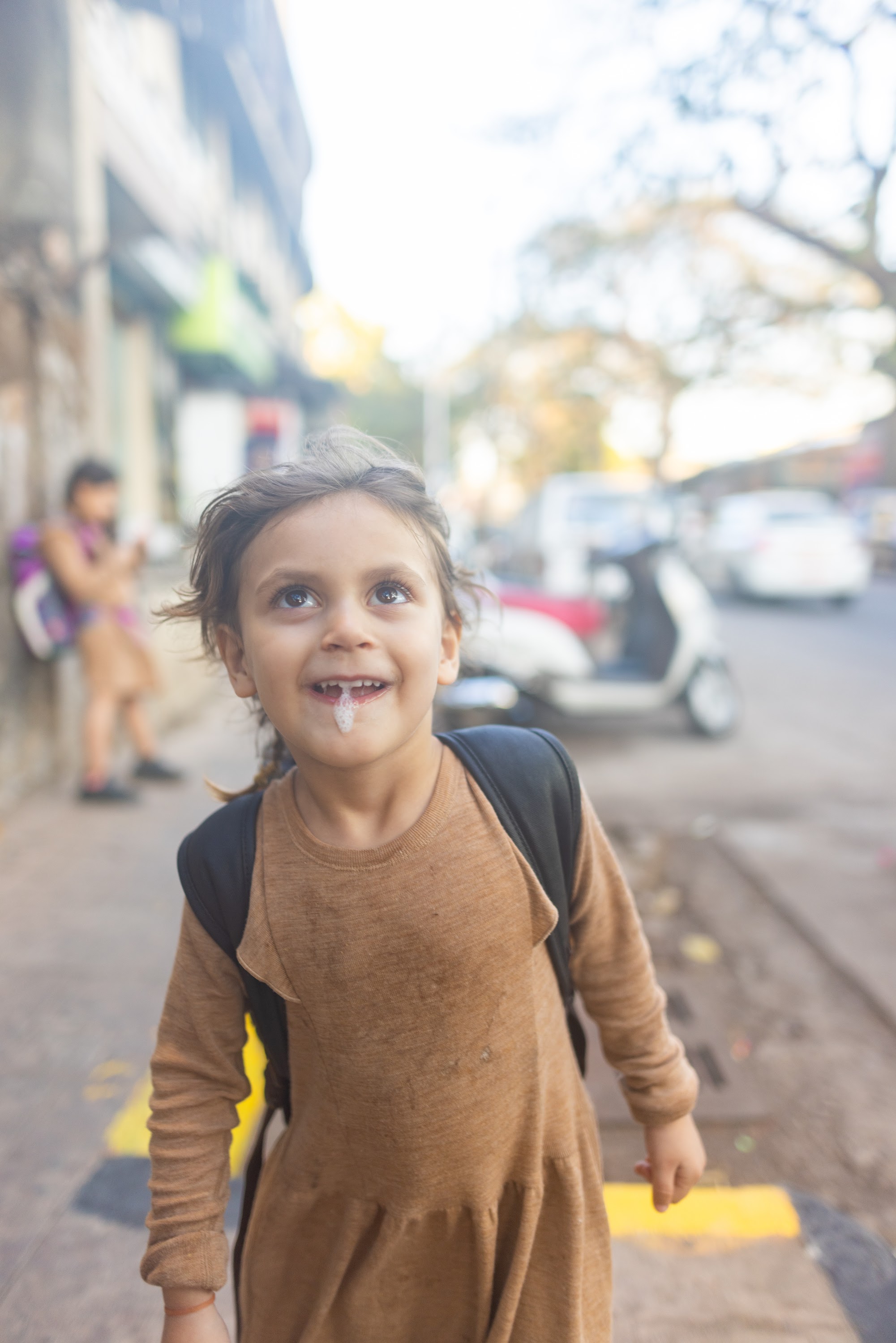 Smiling Girl on Street with Milk on Lip