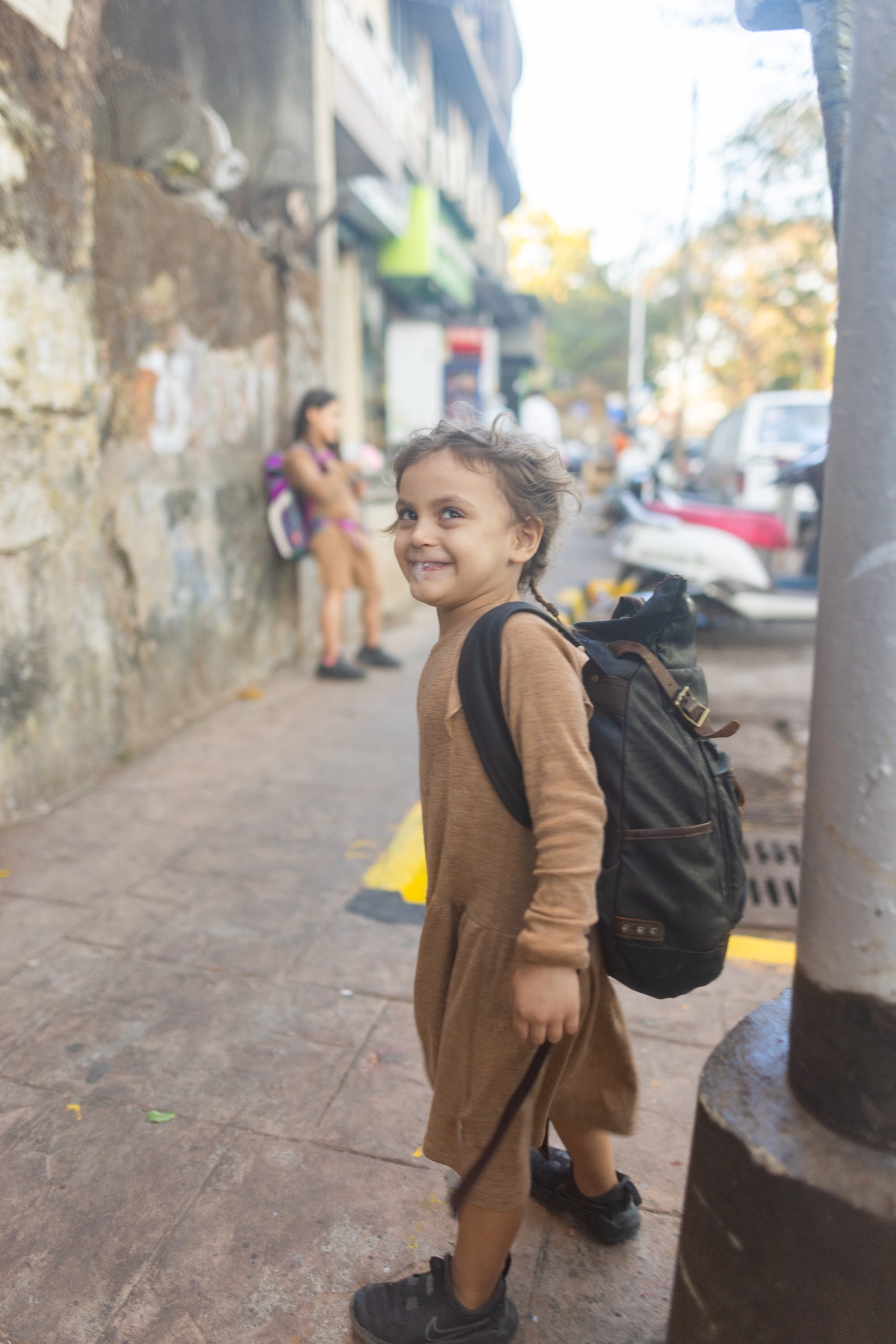 Smiling Child with Backpack on Street