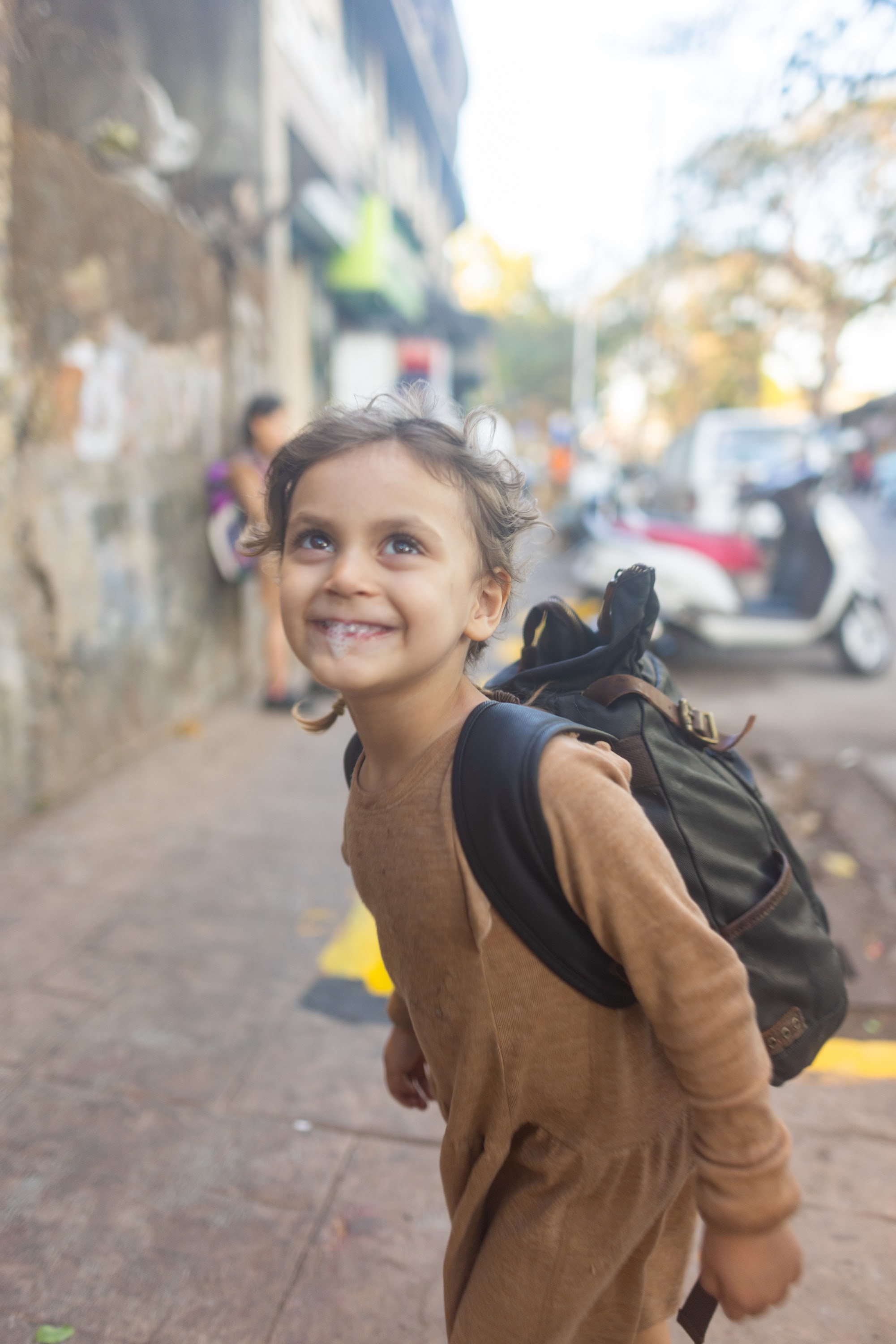 Smiling Child with Backpack on Street