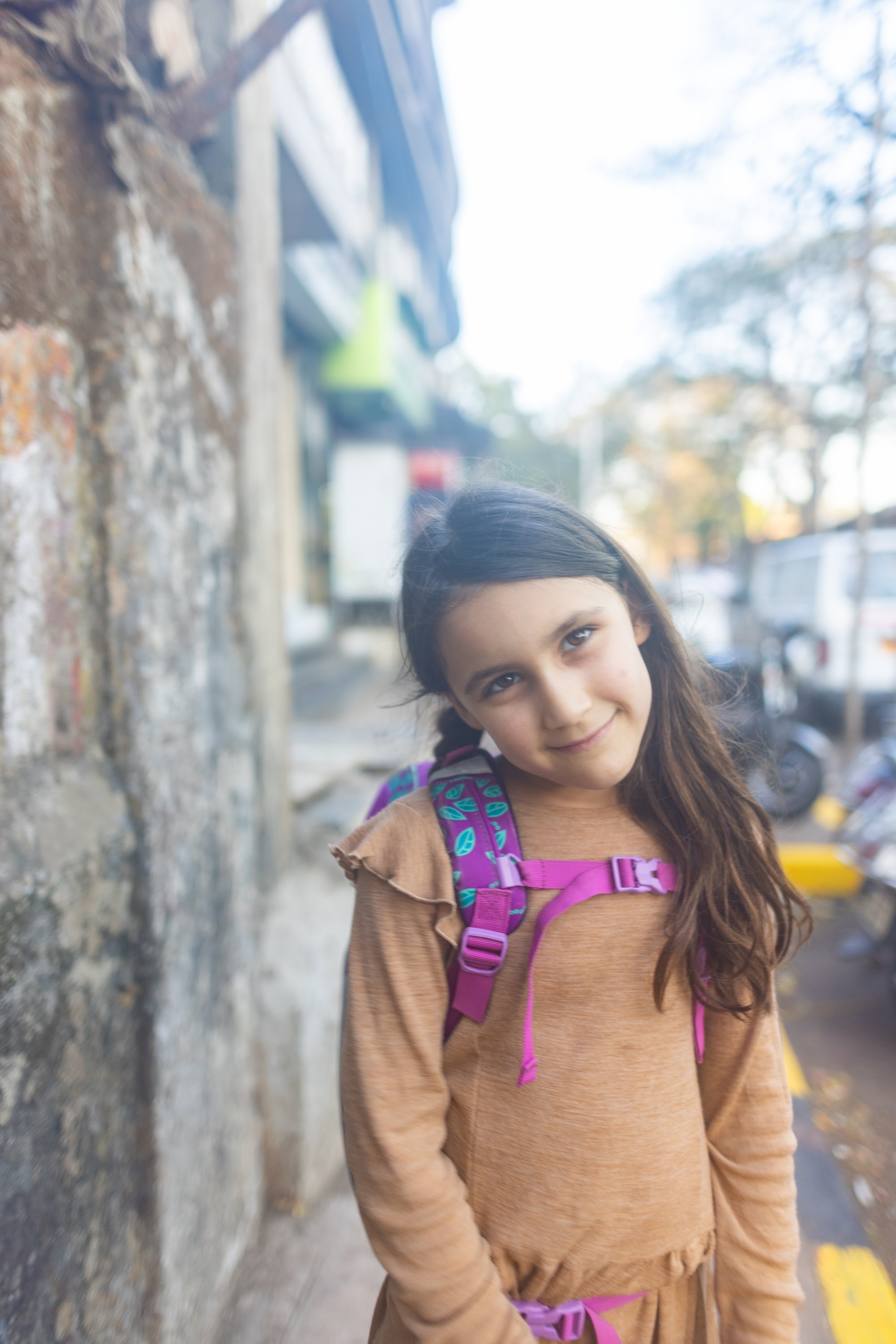 Girl with Backpack Smiling on Street