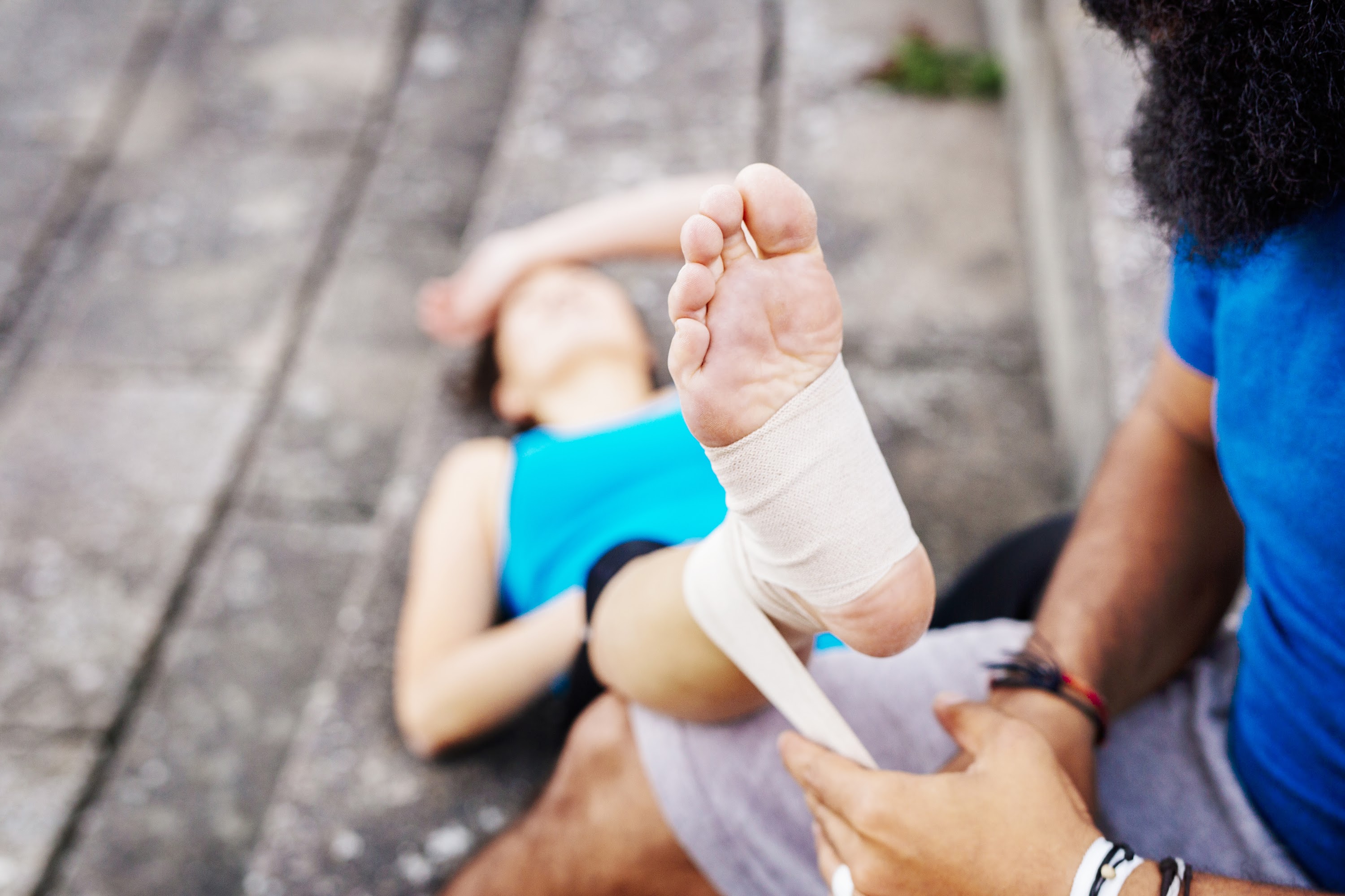 man-wrapping-foot-of-woman-in-bandage-2023-11-27-05-02-16-utc.jpg