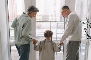 senior-couple-with-granddaughter-near-glass-doorwa-2024-05-08-23-54-16-utc.jpg