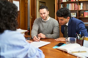 three-people-are-sitting-at-a-table-with-papers-an-2024-06-06-17-54-11-utc.jpg