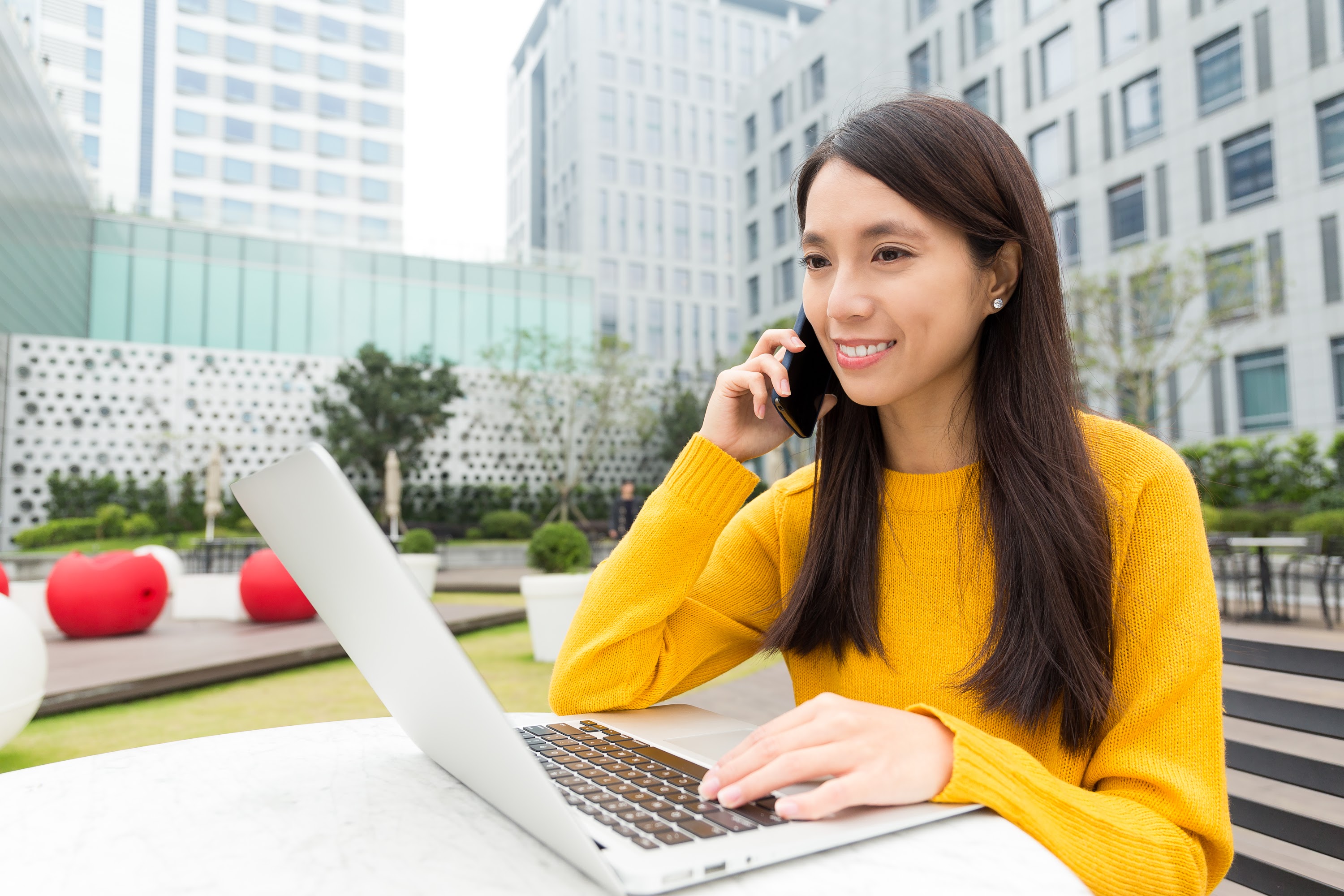 young-woman-chatting-on-cellphone-with-laptop-comp-2023-11-27-05-34-24-utc.jpg