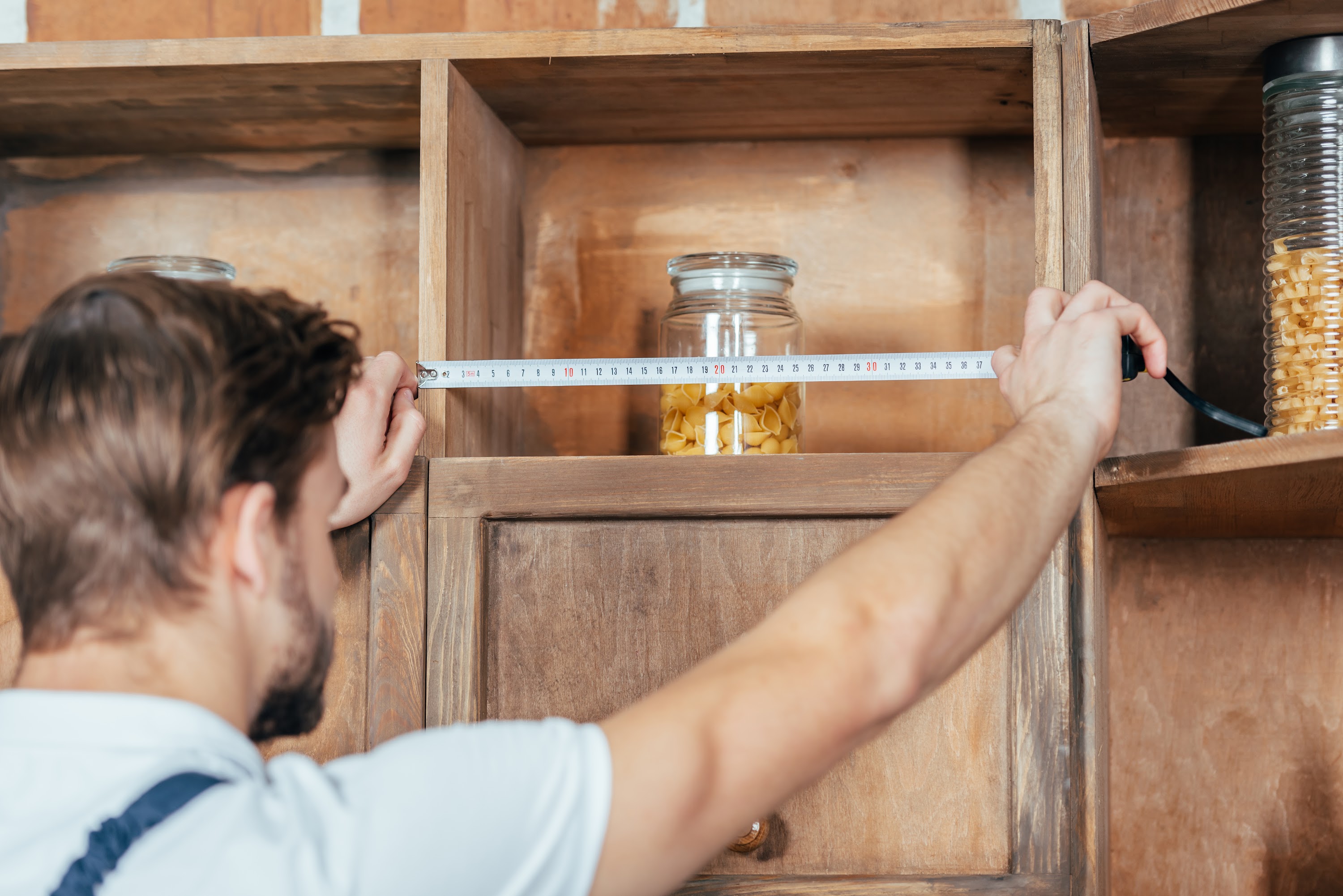 selective-focus-of-young-handyman-measuring-kitche-2023-11-27-05-12-00-utc.jpg