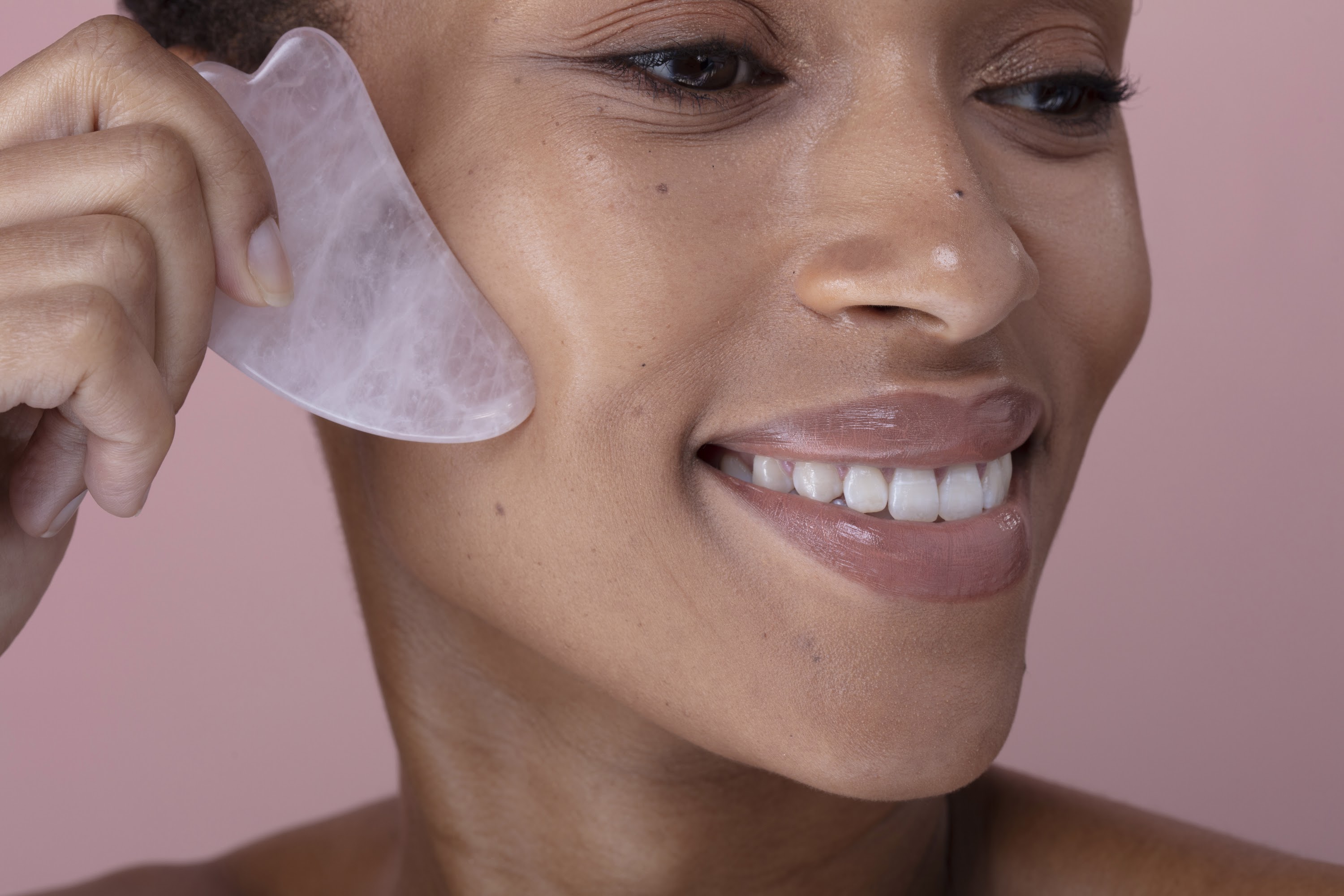 close-up-of-smiling-woman-massaging-face-with-rose-2024-07-05-20-23-17-utc.jpg