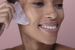 close-up-of-smiling-woman-massaging-face-with-rose-2024-07-05-20-23-17-utc.jpg