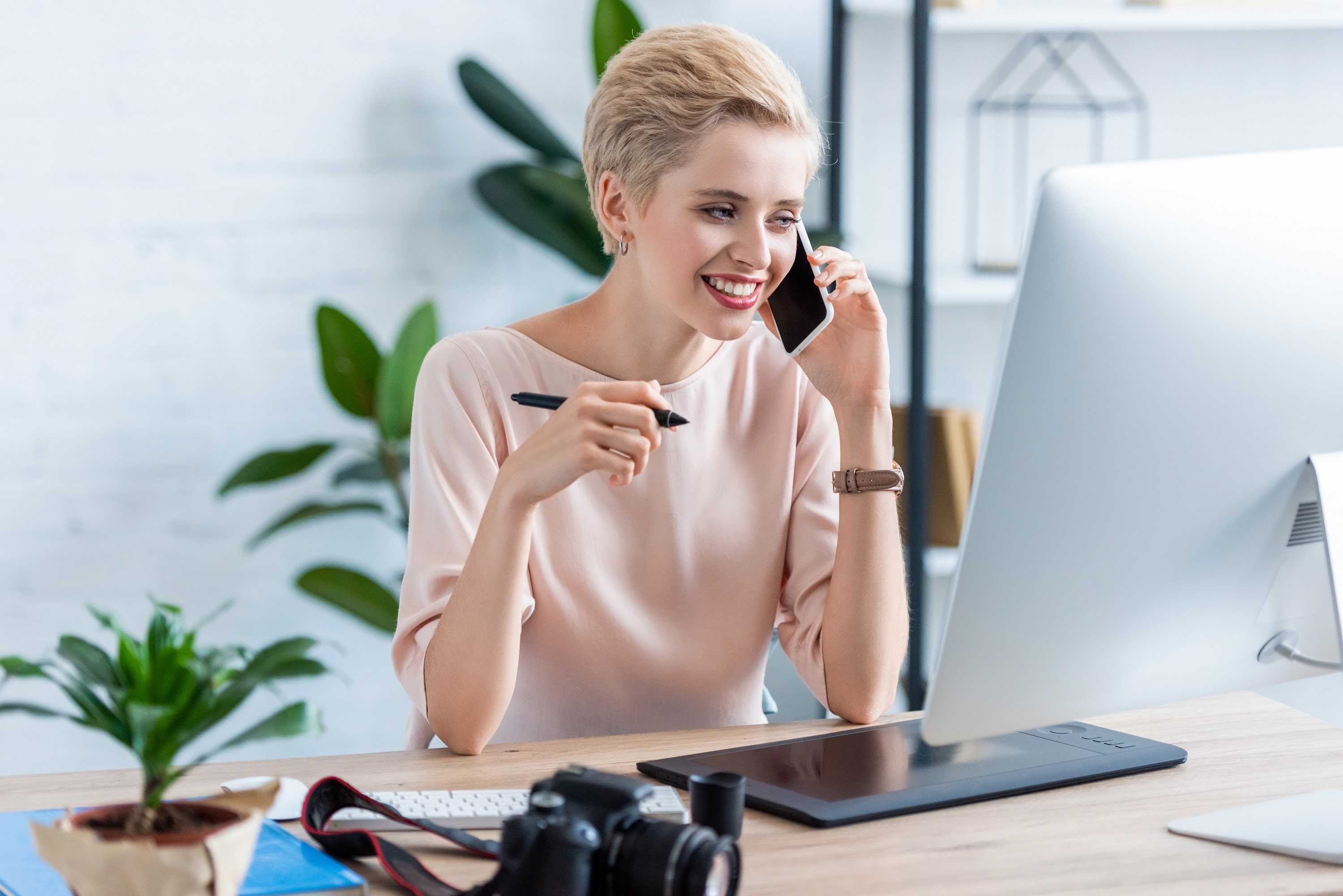 smiling-female-photographer-talking-on-smartphone-2023-11-27-05-16-52-utc.jpg