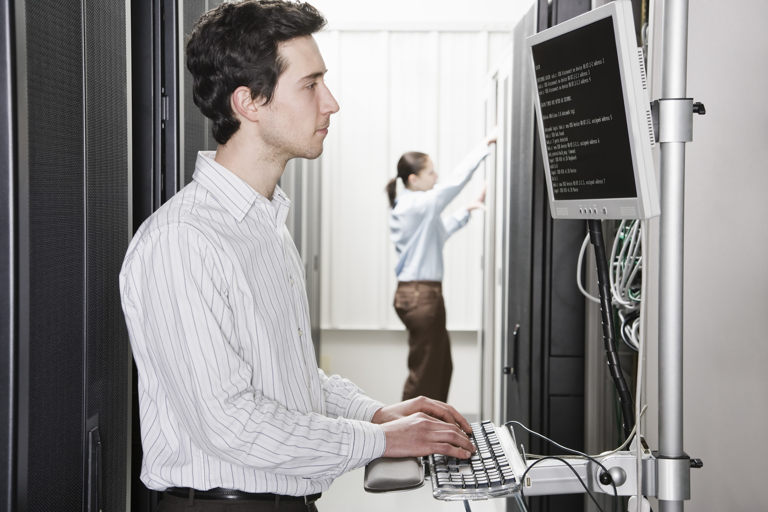 a-male-computer-technician-standing-in-an-aisle-of-2023-11-27-05-02-28-utc.jpg