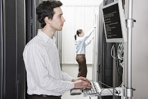 a-male-computer-technician-standing-in-an-aisle-of-2023-11-27-05-02-28-utc.jpg