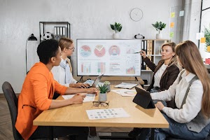 four-female-partners-sitting-at-desk-and-discussin-2023-11-27-05-34-29-utc.jpg