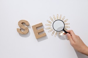 wooden-letters-and-hand-with-magnifying-glass-on-w-2023-12-22-22-55-05-utc.jpg