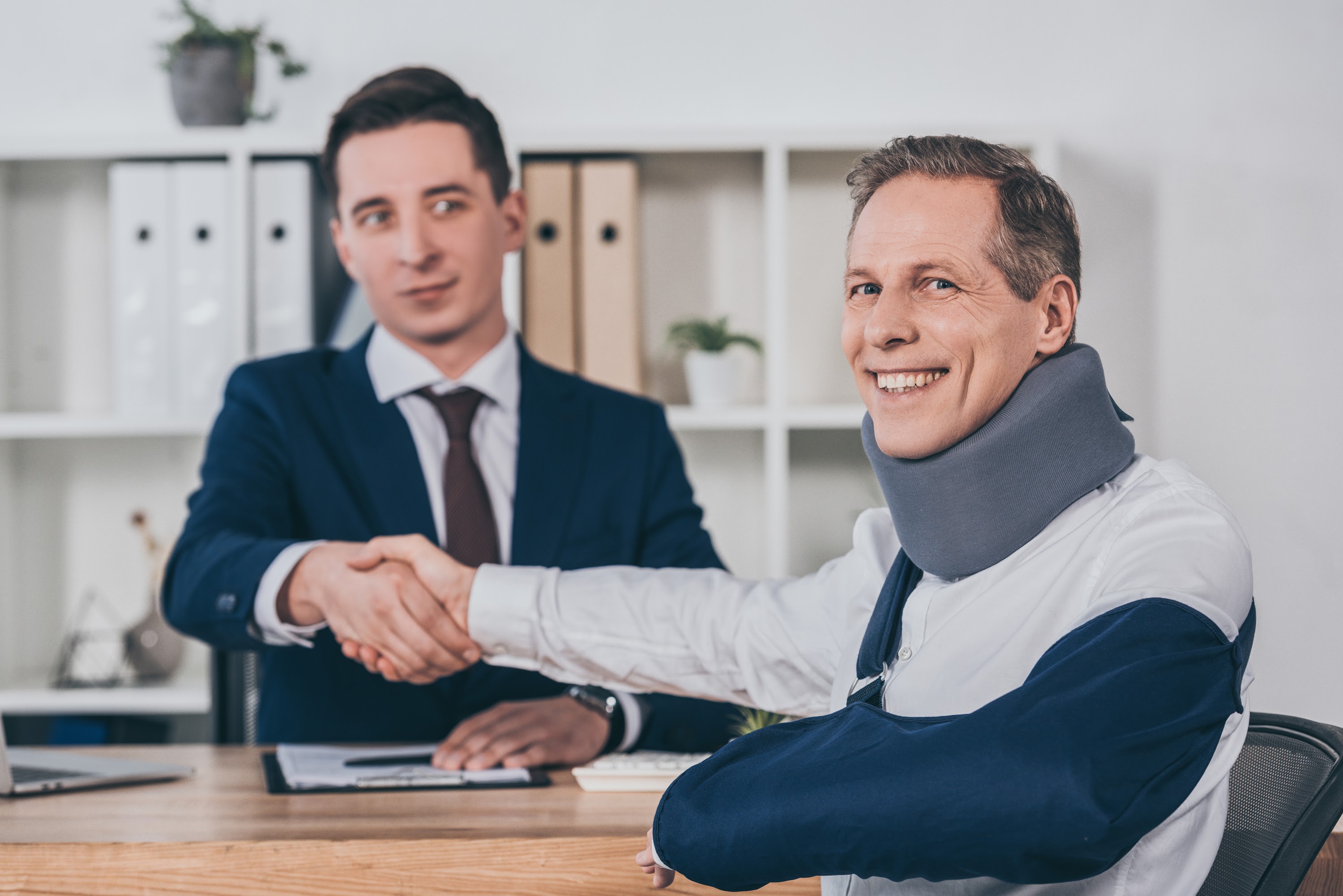 businessman-shaking-hands-with-worker-in-neck-brac-2024-11-17-10-35-40-utc.jpg