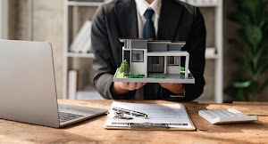 a-real-estate-agent-holding-a-small-new-house-in-h-2023-11-27-05-30-33-utc.jpg