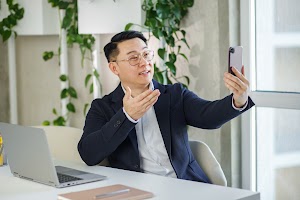 smiling-asian-businessman-waving-hand-during-video-2023-11-27-05-00-17-utc.jpg