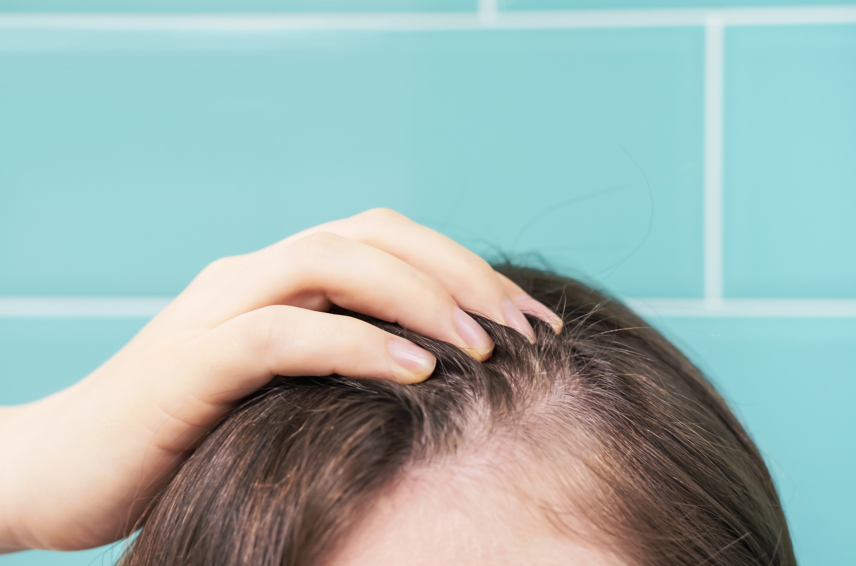 woman-touching-her-hair-close-up-on-against-backgr-2025-01-10-11-23-20-utc.jpg