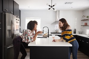 two-female-friends-drinking-wine-at-home-standing-2024-10-19-09-30-35-utc.jpg
