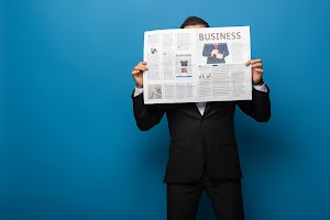 businessman-covering-face-with-newspaper-on-blue-b-2024-11-11-18-22-10-utc.jpg