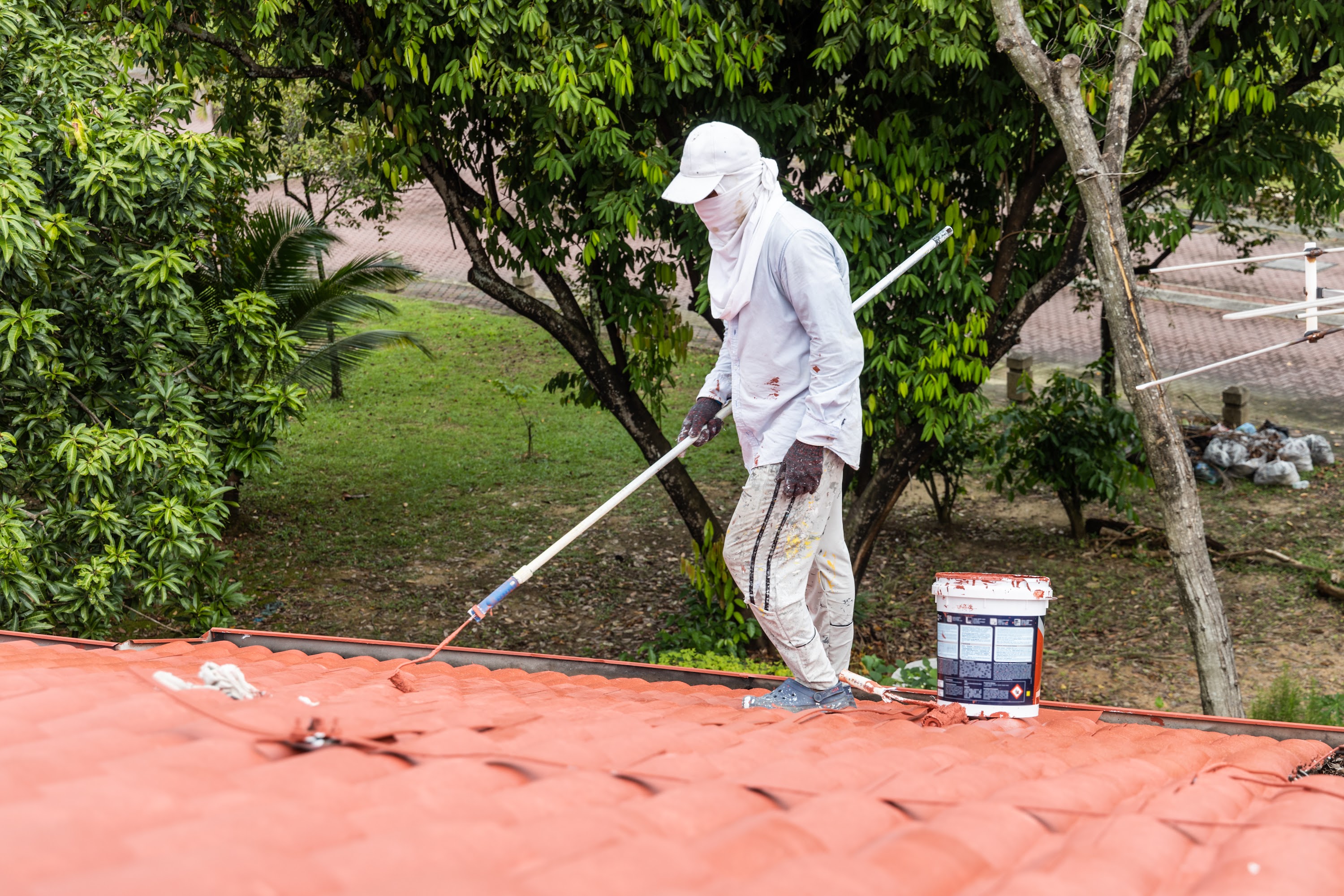worker-painting-red-rooftop-with-roller-at-residen-2025-03-08-23-03-08-utc.jpg