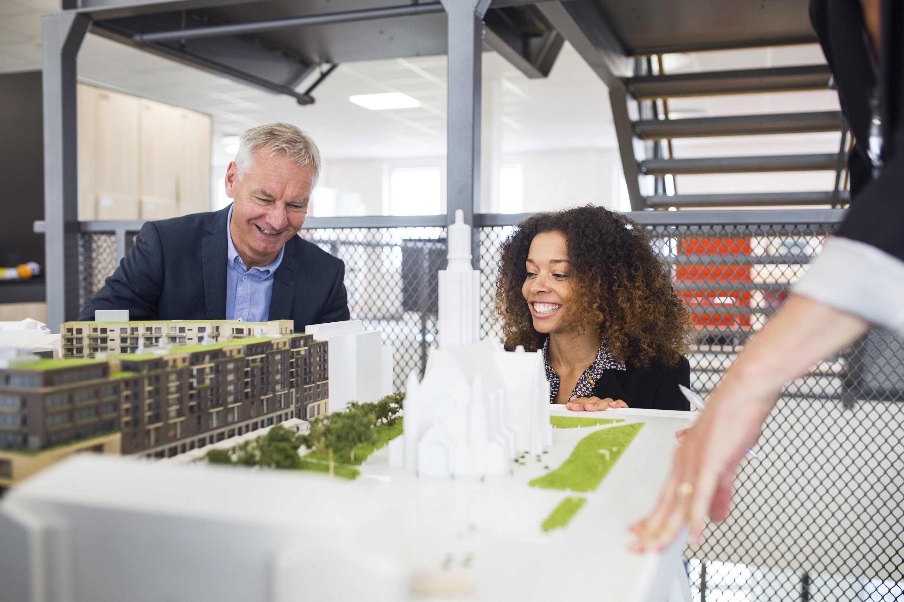 colleagues-discussing-a-scale-model-building-proje-2025-04-04-00-32-42-utc.jpg