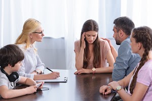 female-counselor-writing-in-clipboard-while-family-2024-11-18-21-24-31-utc.jpg